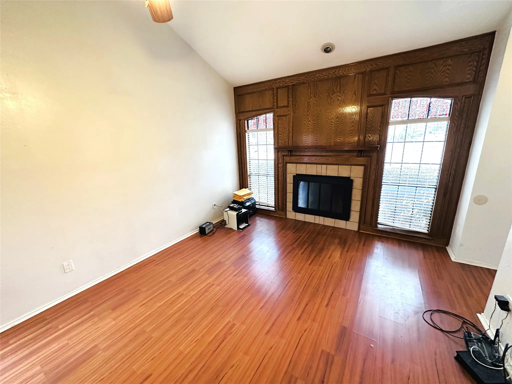 Living area featuring a vaulted ceiling and wood-finish flooring