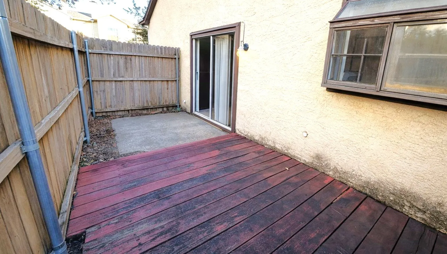 Outdoor deck area featuring wood plank flooring and a concrete patio