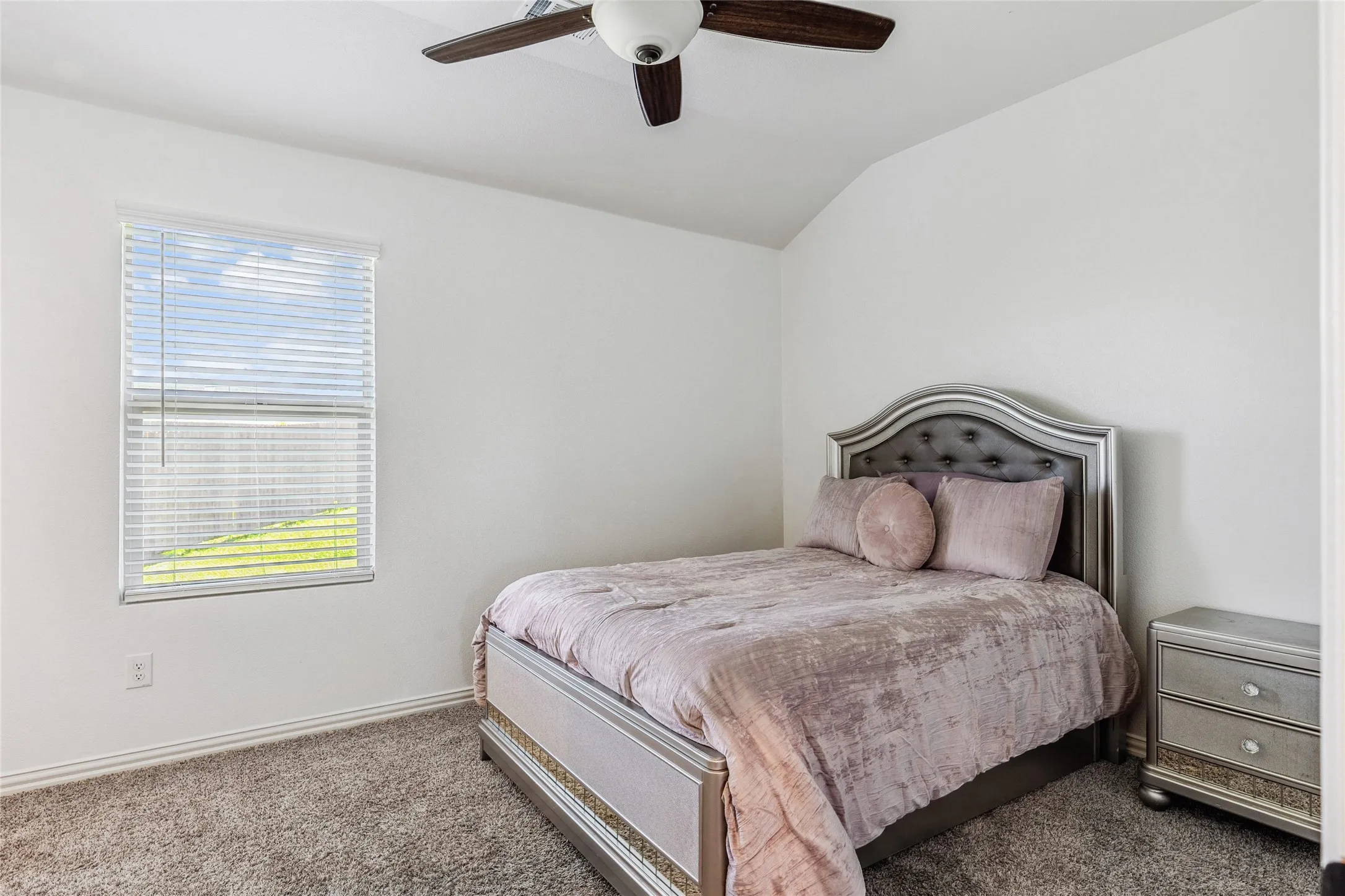Interior room featuring a ceiling fan with light fixture, carpet flooring, a window with horizontal blinds, and white walls