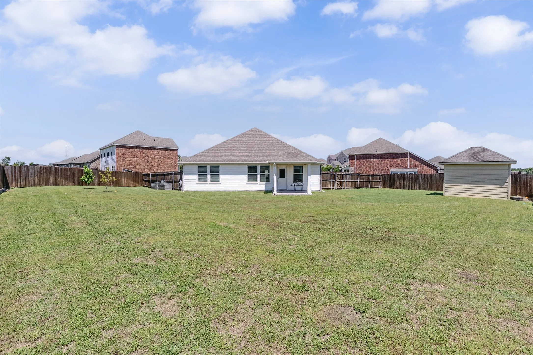 Expansive green lawn with a wood privacy fence