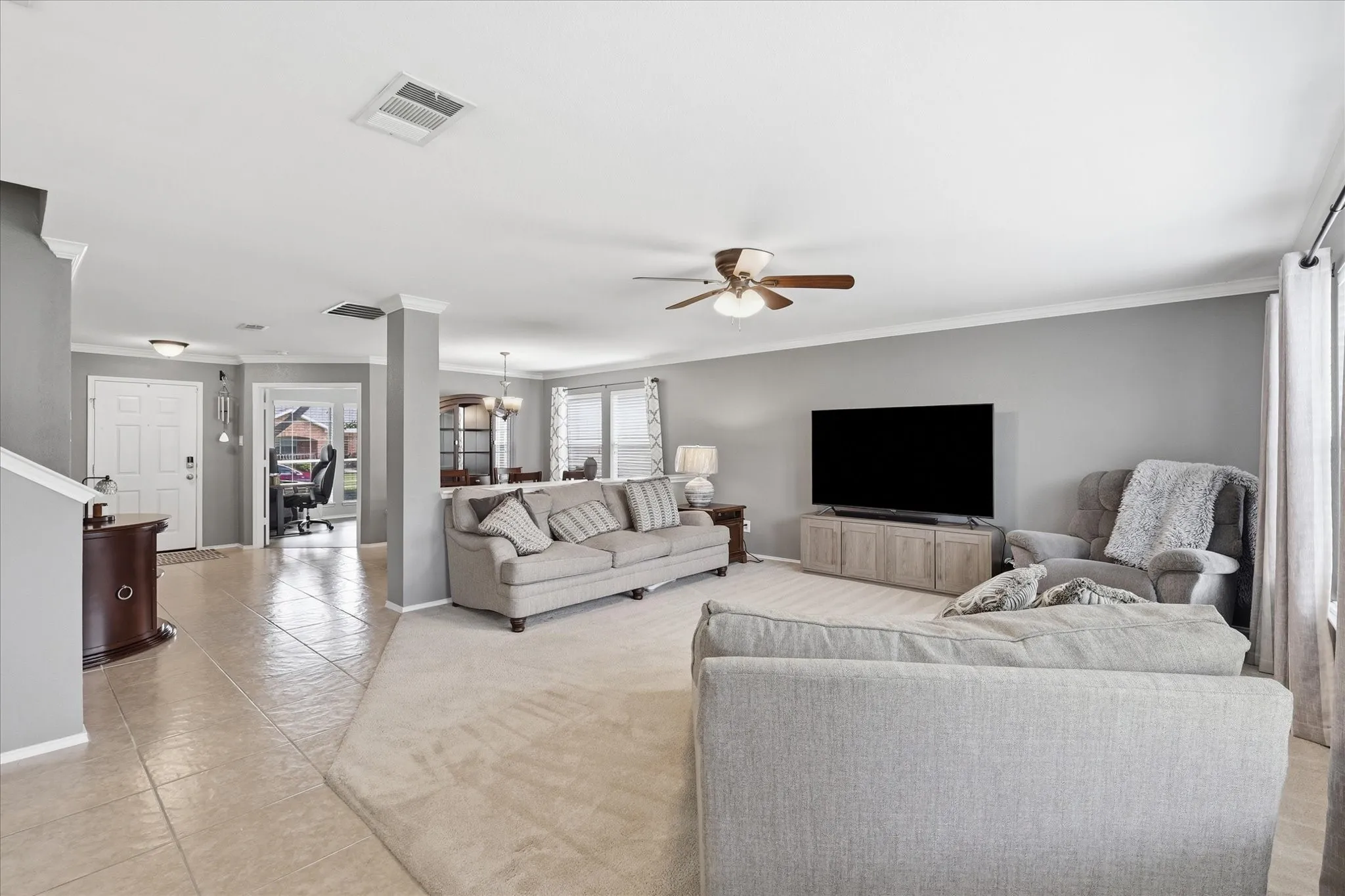 Expansive living area featuring light gray wall tones and crisp white trim