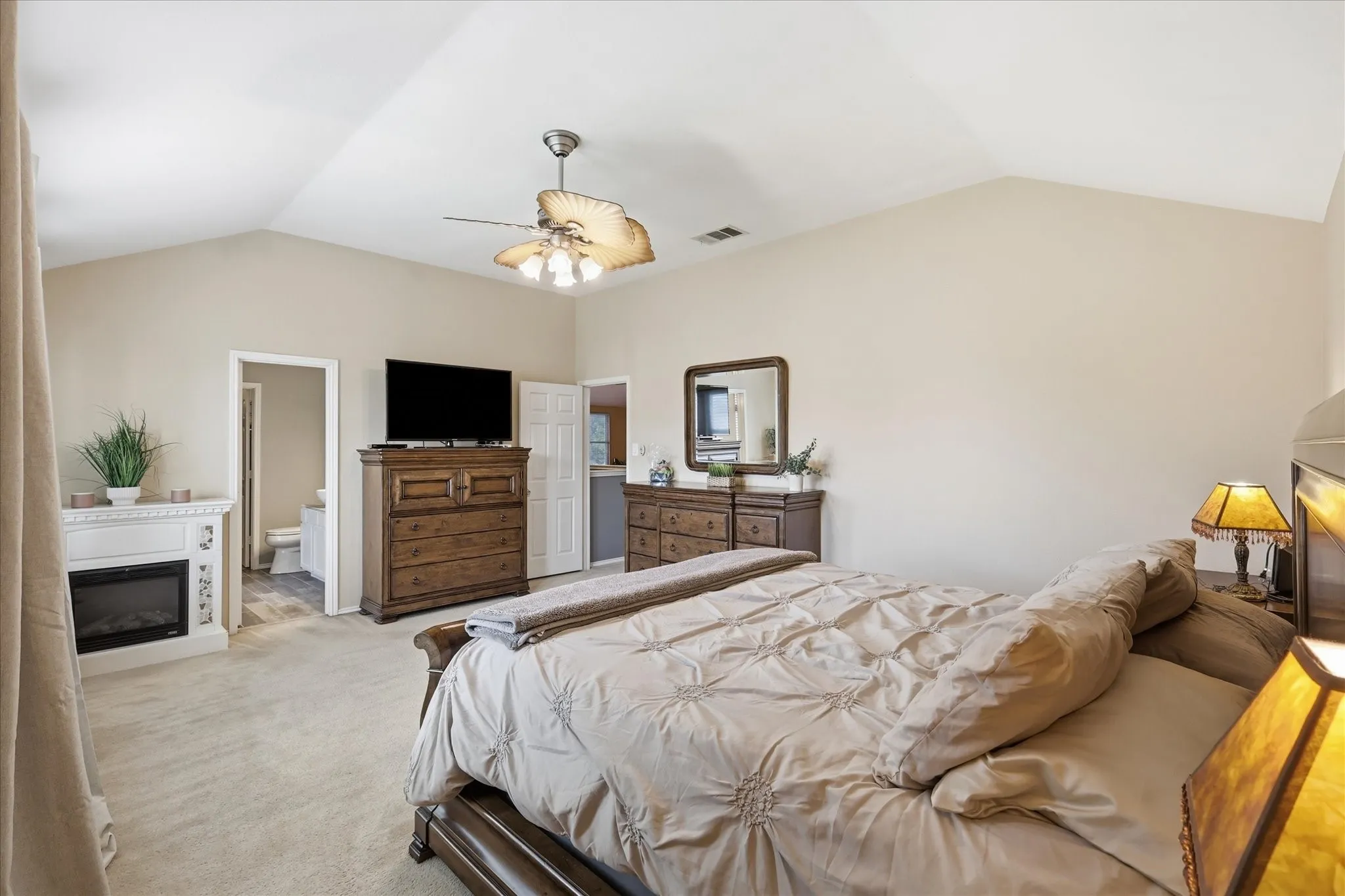 Vaulted ceiling bedroom featuring plush carpeting and neutral wall tones