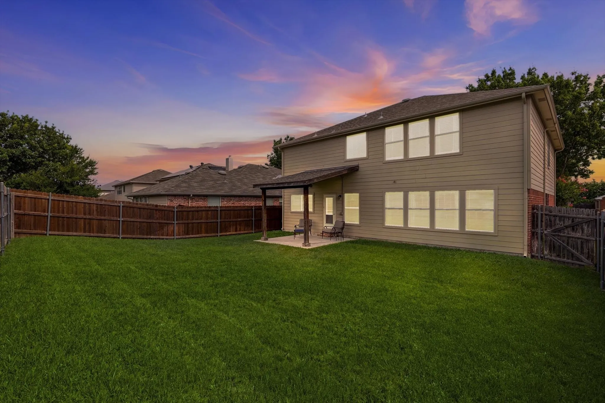 Evening-Expansive green lawn with a full privacy fence
