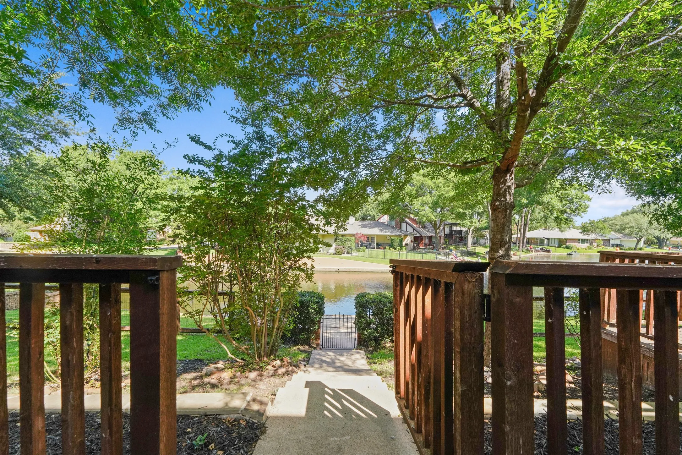 Wooden gate opening to a concrete pathway