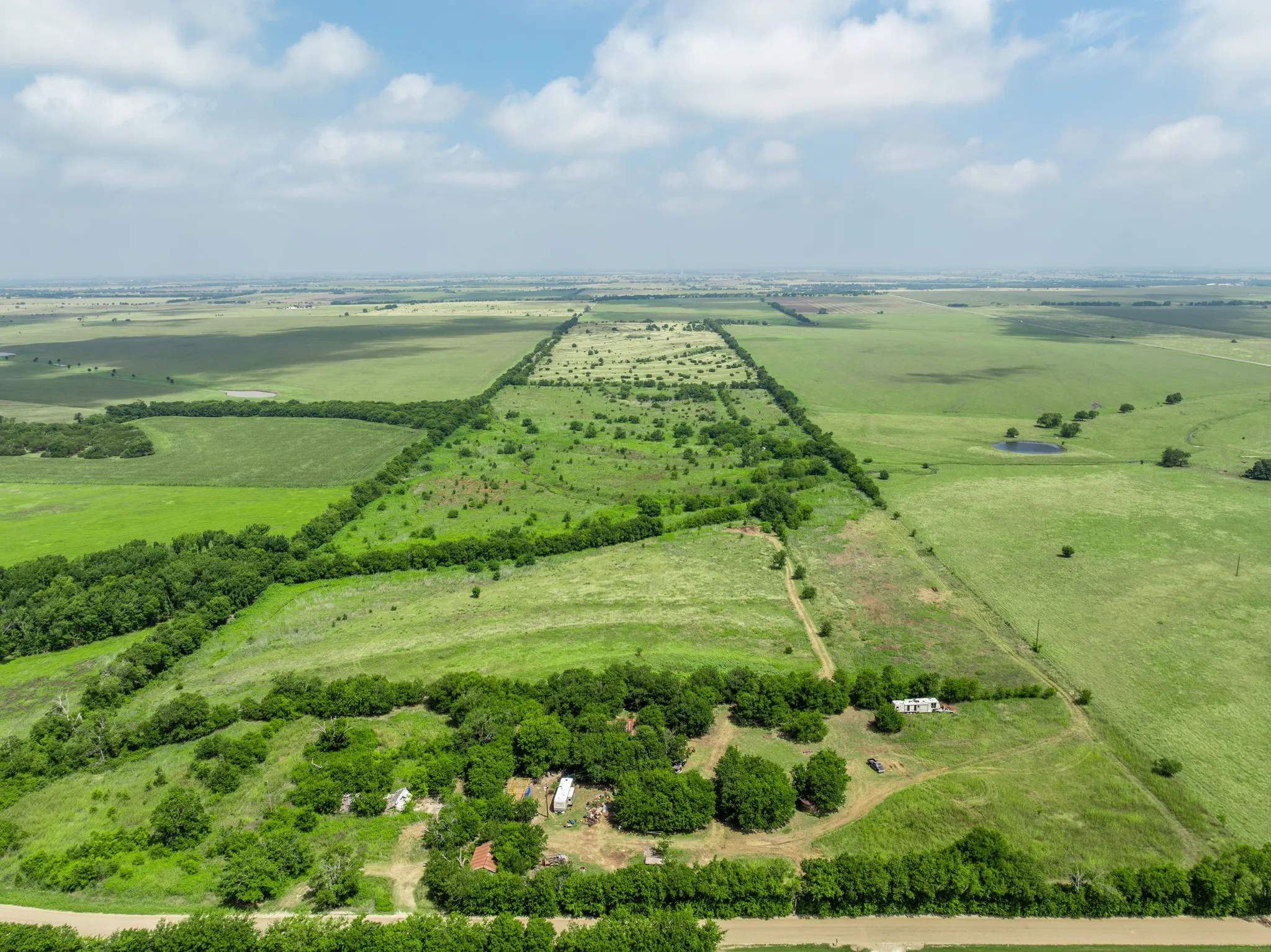 Expansive land parcel featuring open fields and natural tree lines