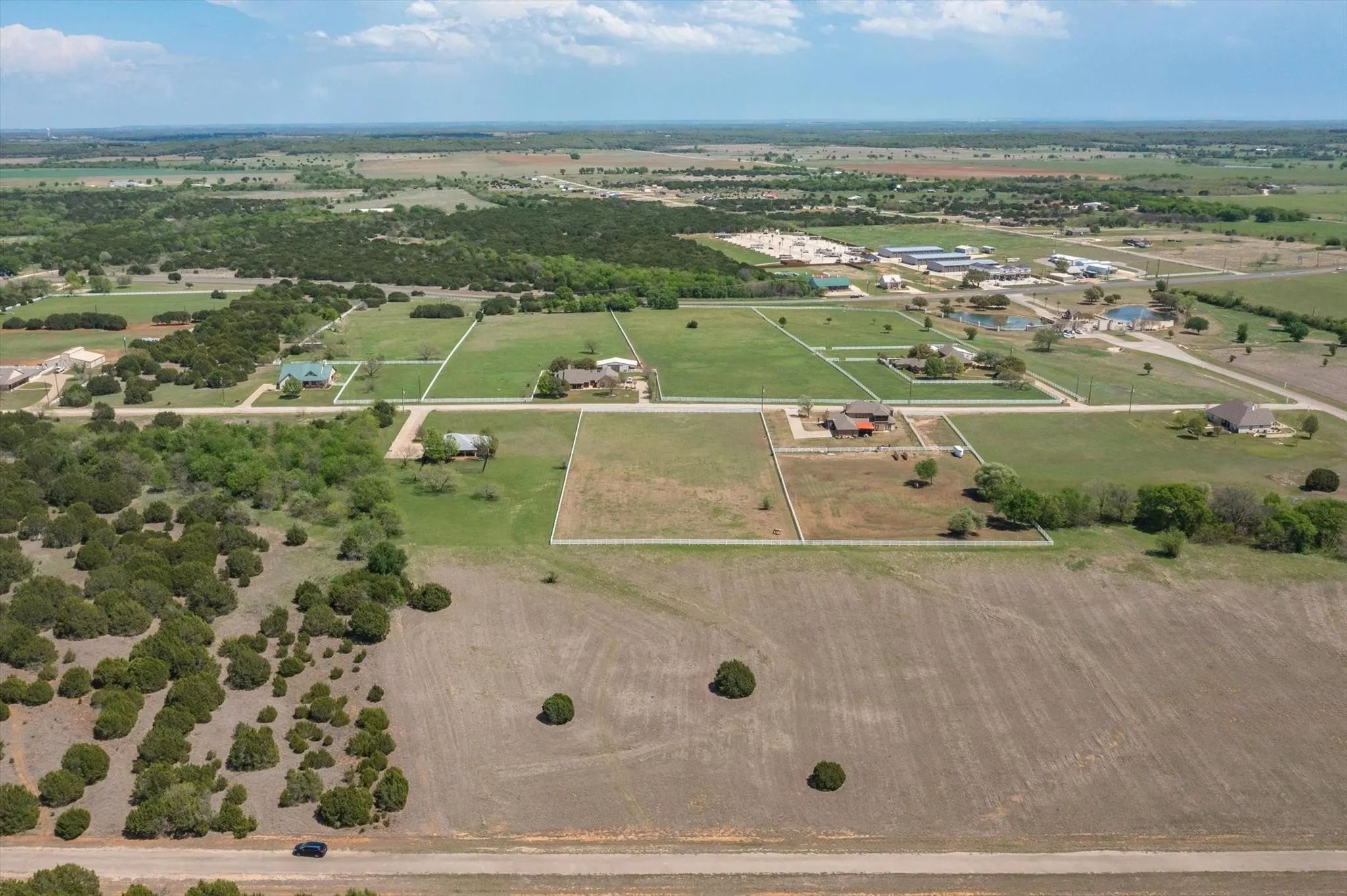 Expansive land parcels with clear boundaries, surrounded by a mixture of mature trees and open fields