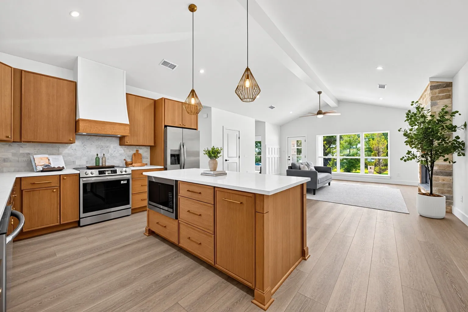 Open-concept kitchen with a central island, wood-finish cabinetry, and stainless steel appliances