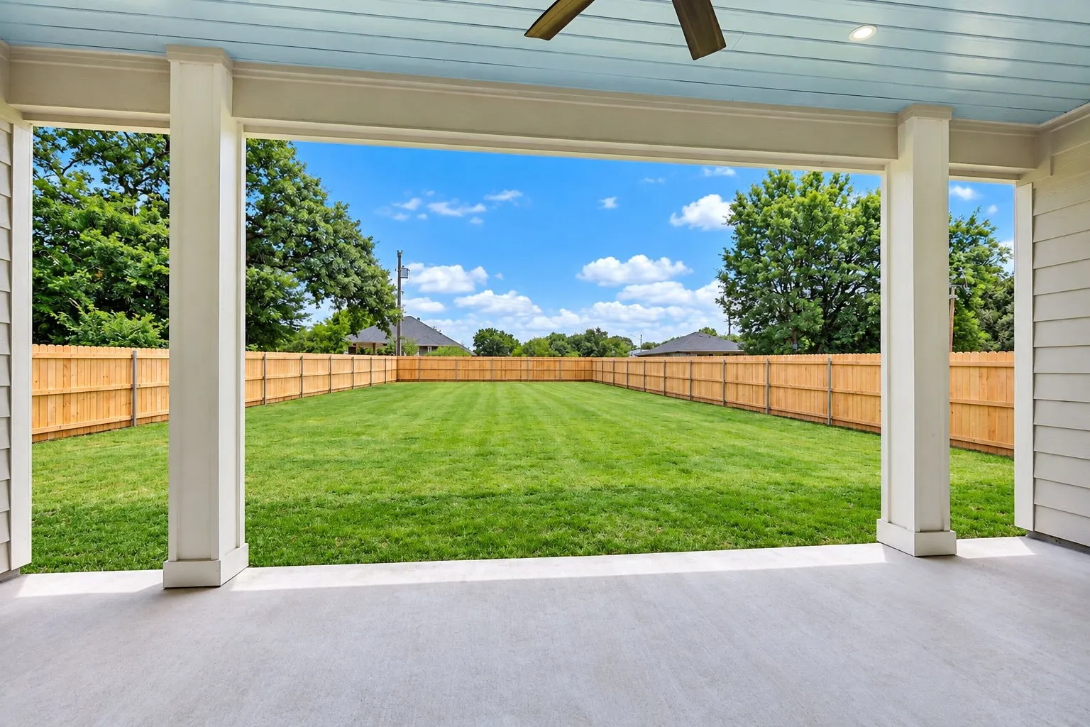 Covered patio with a wood-finish ceiling, mounted ceiling fan, and recessed lighting
