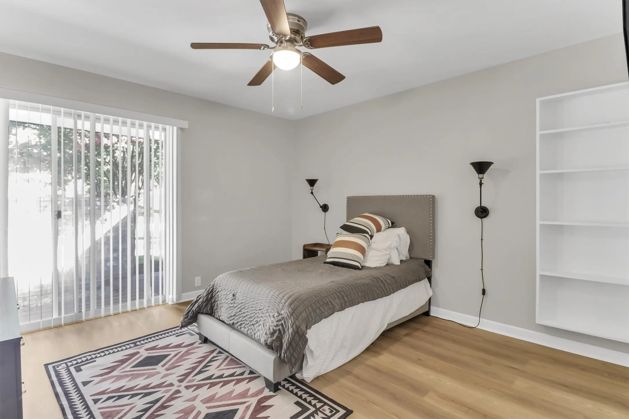 Light wood-finish flooring with a ceiling fan featuring a light fixture
