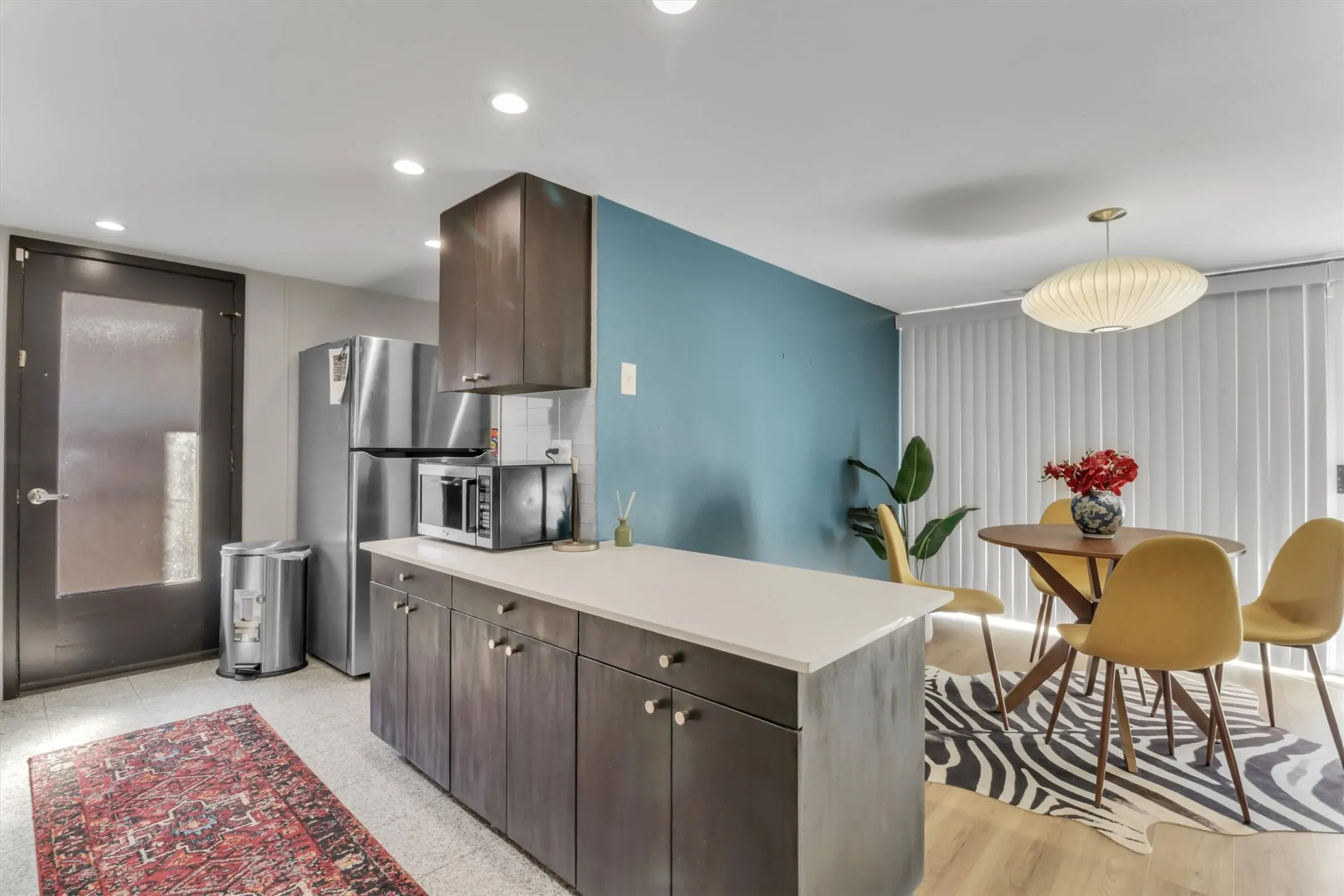 Kitchen featuring dark wood-finish cabinetry, light countertops, and stainless steel appliances