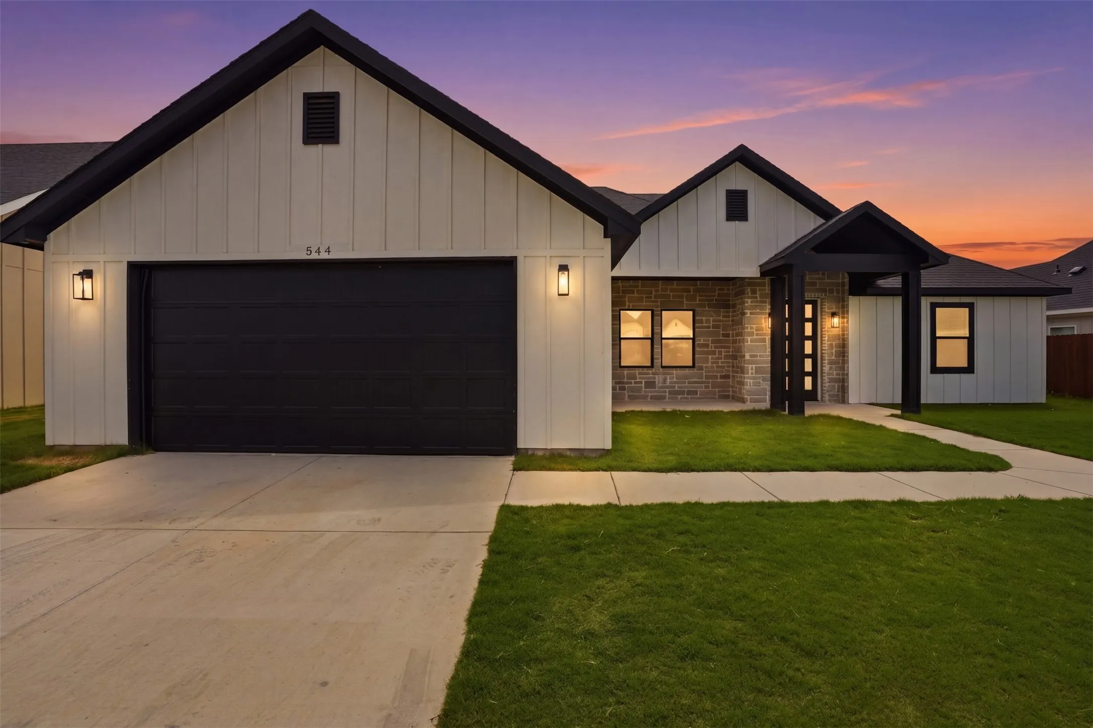 Modern farmhouse-style exterior featuring board and batten siding and stone accents