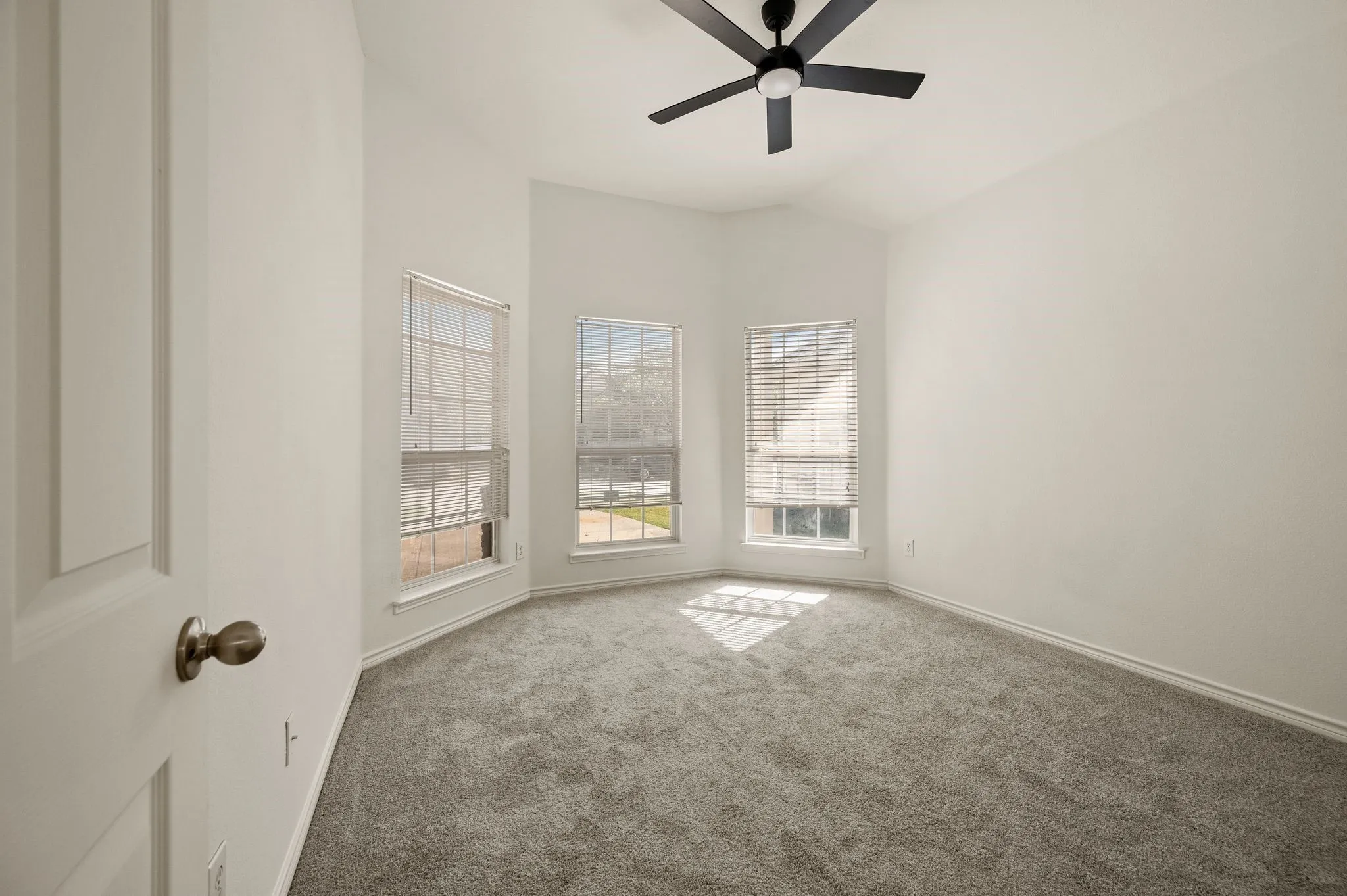 Bright corner bedroom flooded with natural light through three large double-hung windows