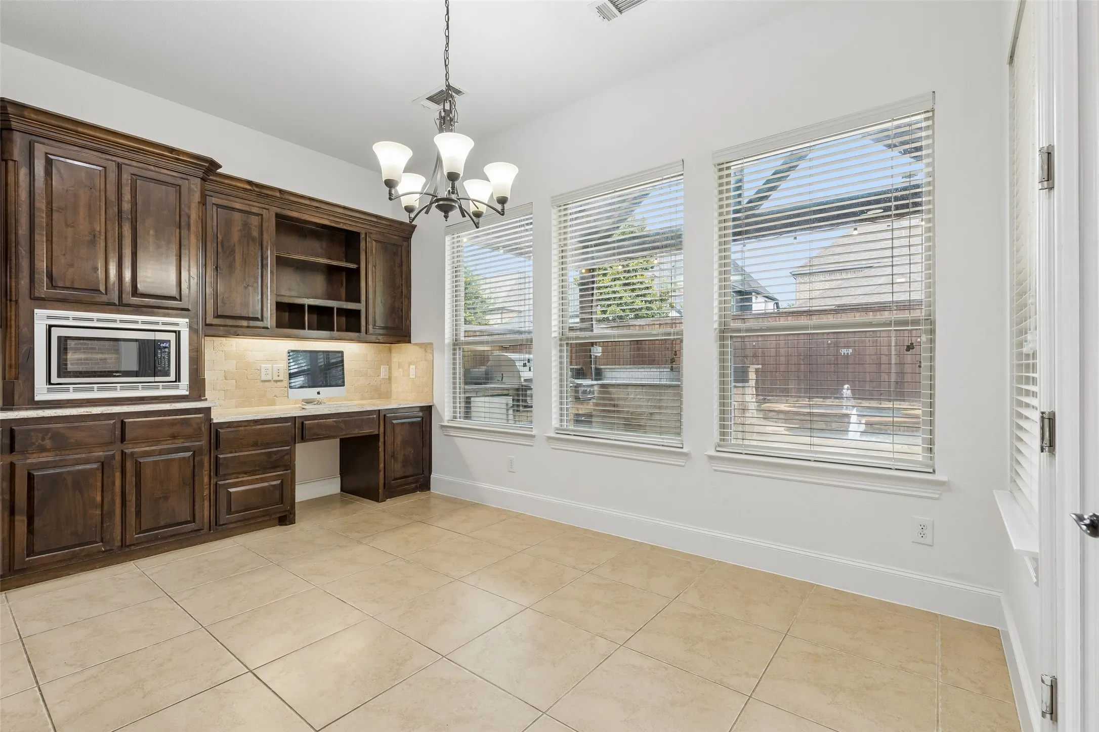 Kitchen with granite counter tops, tile backsplash, SS appliances, oversized kitchen island, planning desk, and walk in pantry.