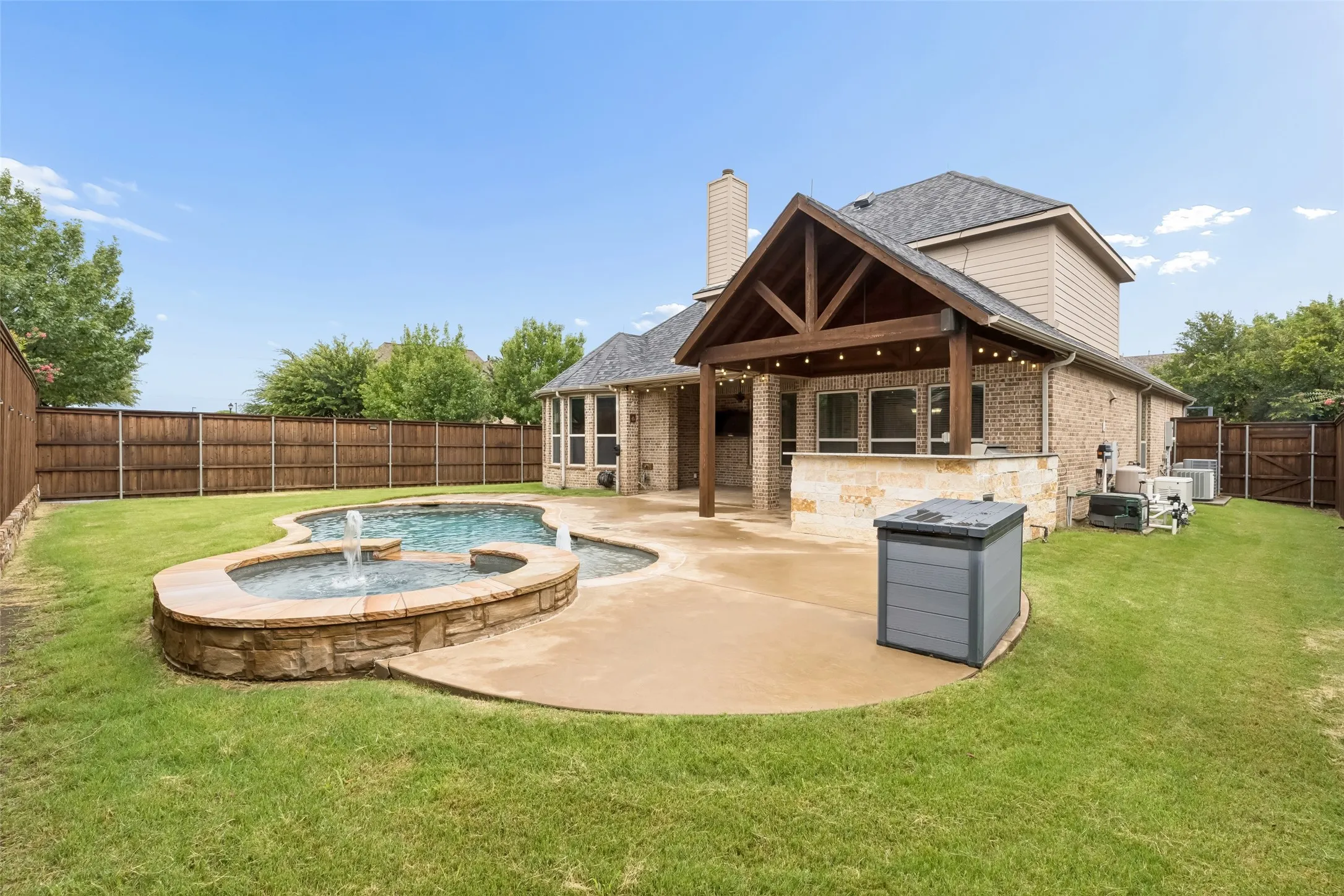 Back yard view of pool & spa & extended covered patio with built in outdoor kitchen.