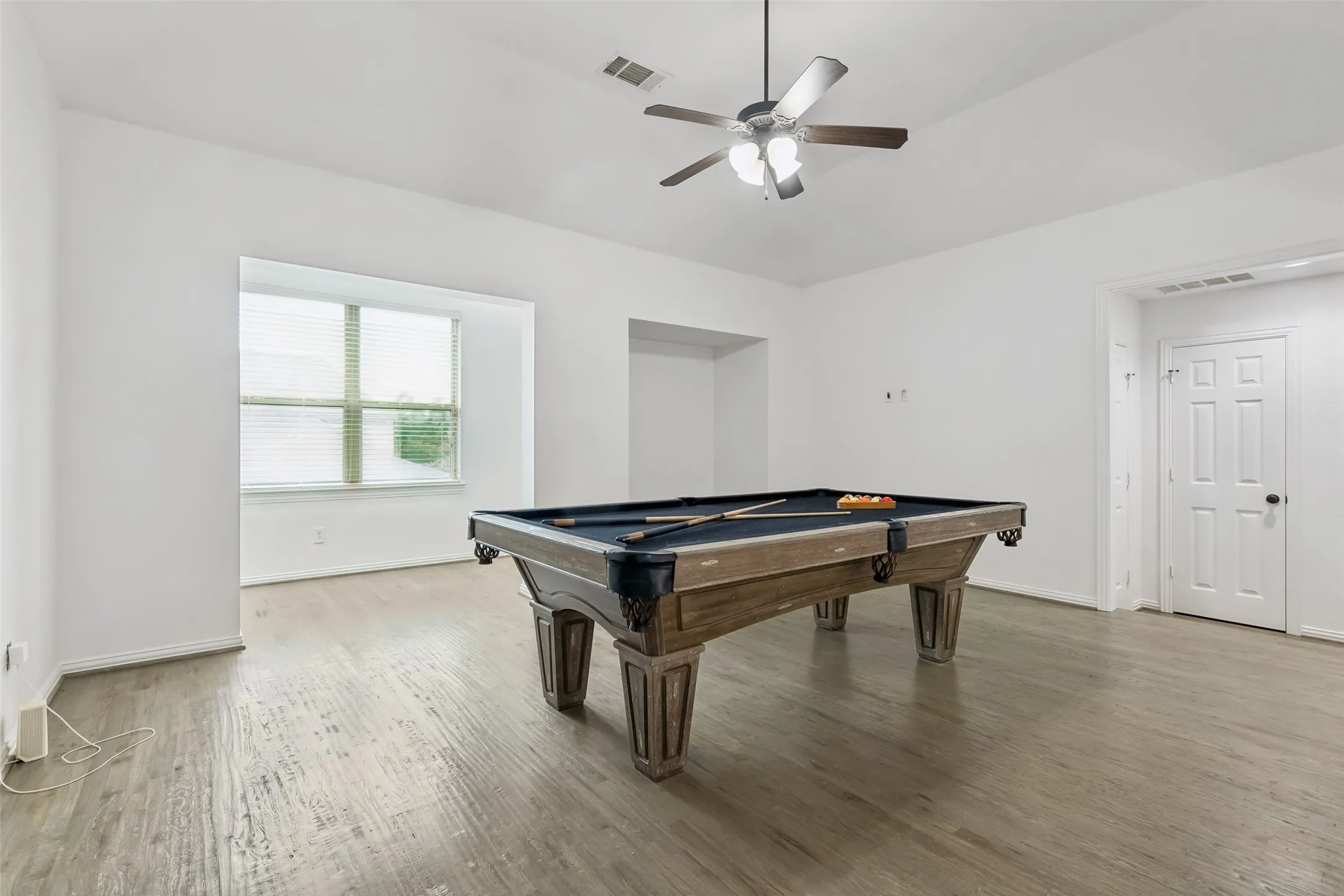 Game room with refinished hardwood floors and pool table.