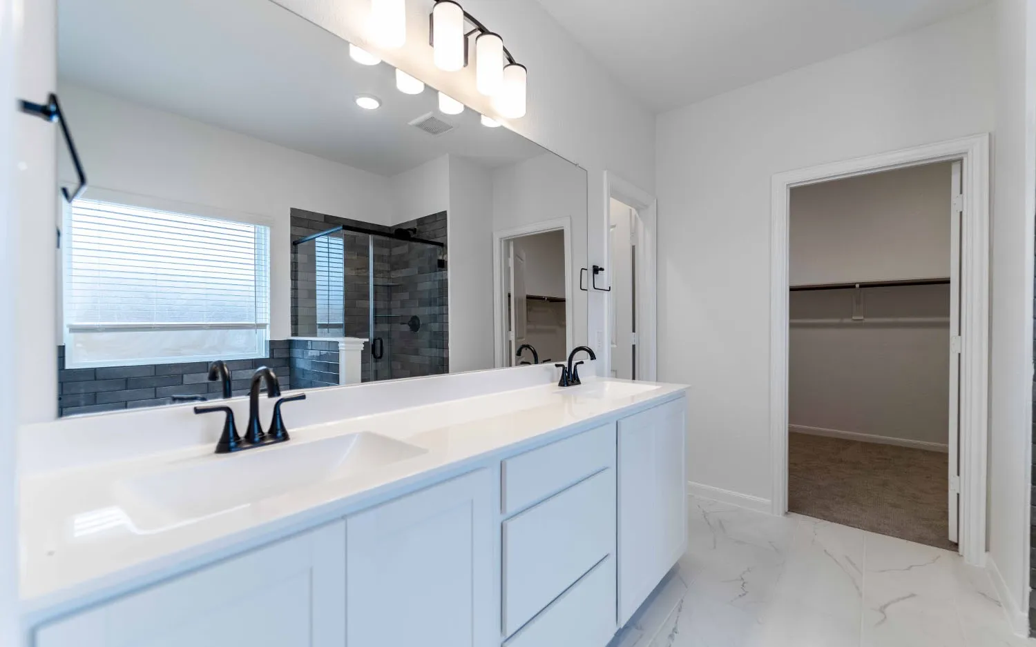 Dual sink vanity with white cabinetry, white countertops, and matte black fixtures
