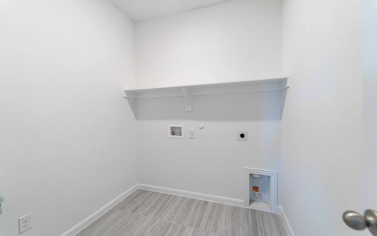 Laundry room featuring wood-finish tile flooring, white shelving, and appliance hookups