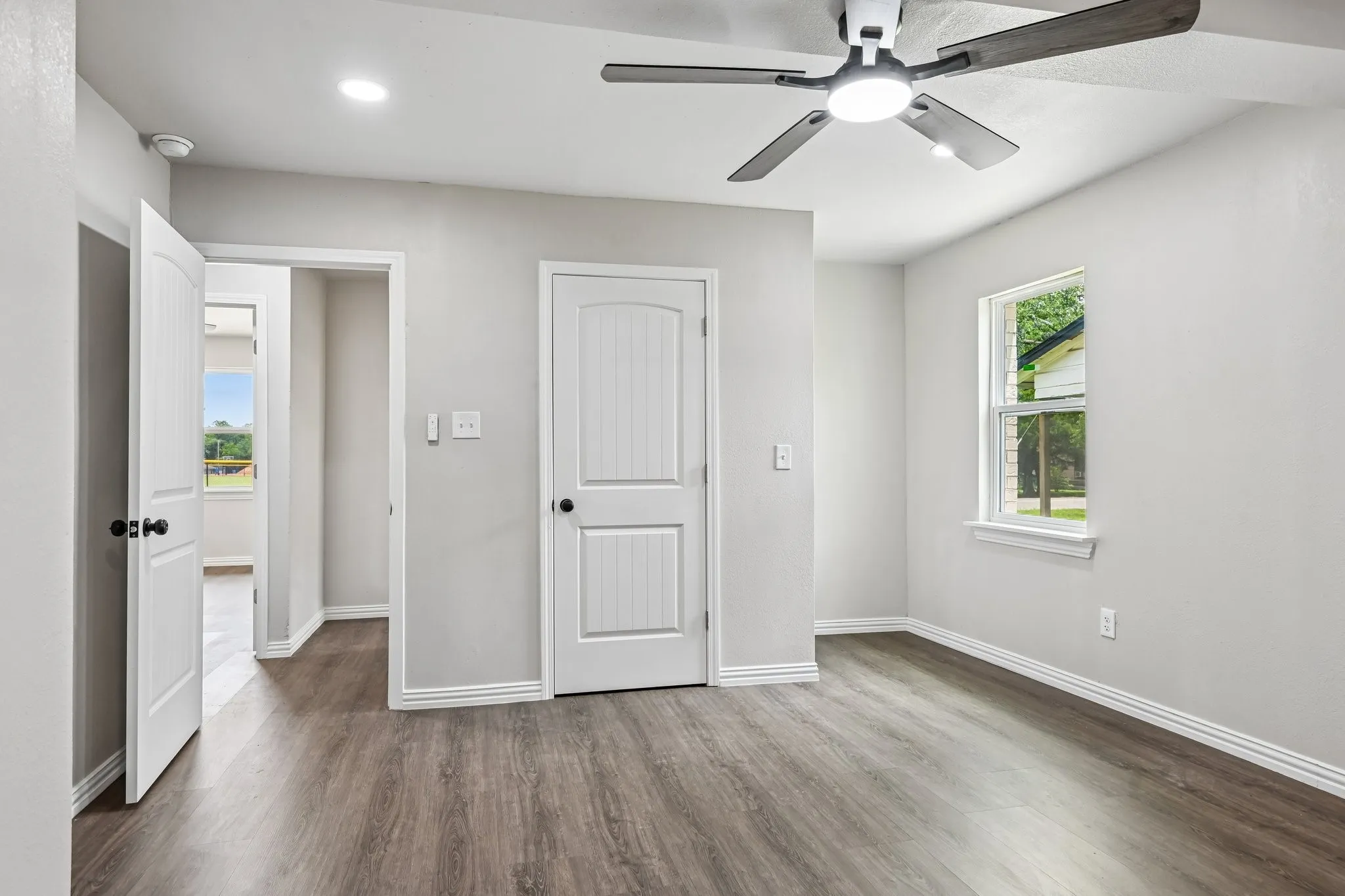 Interior room featuring wood-finish flooring, light grey walls, and white trim