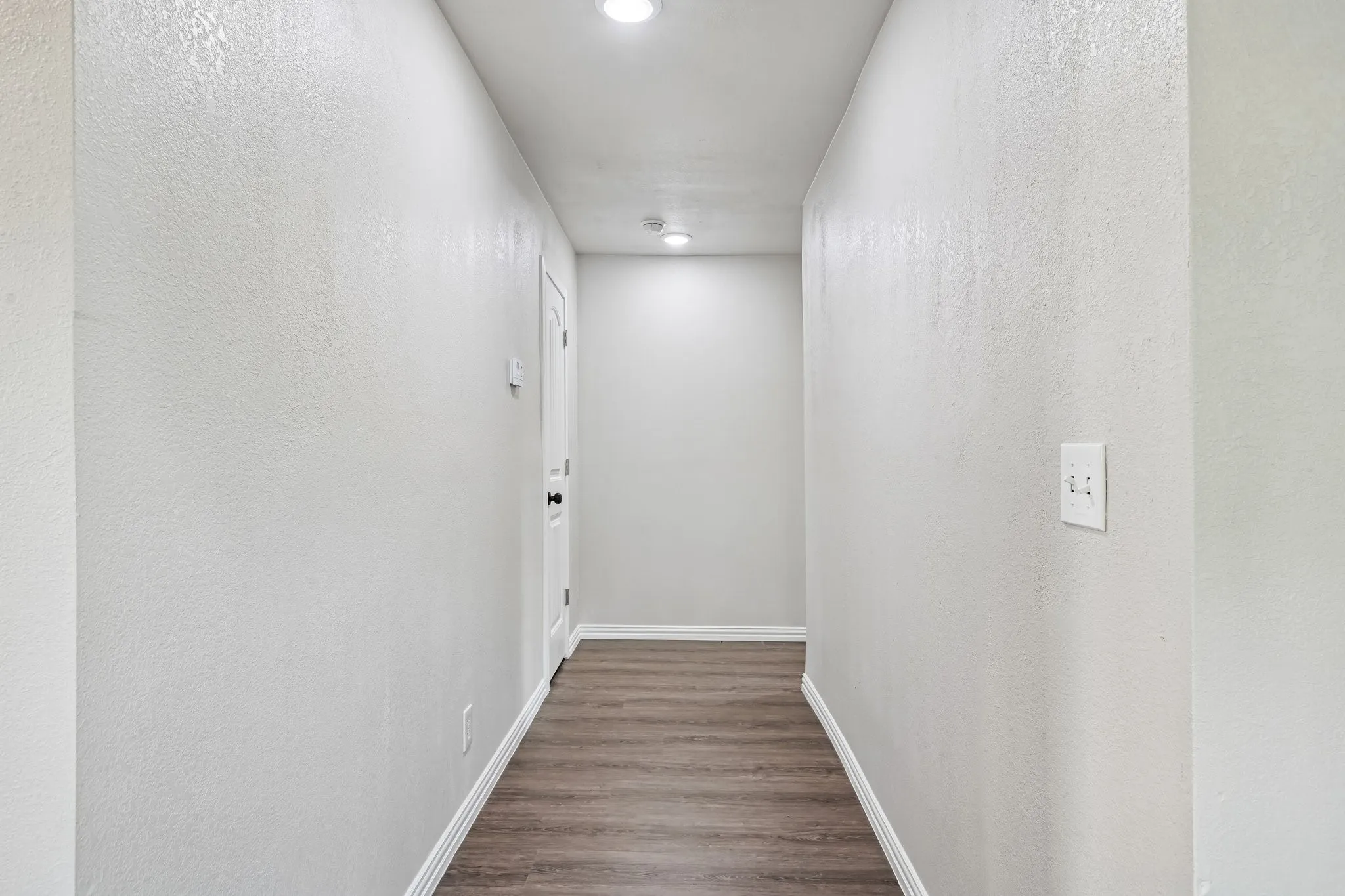 Hallway featuring recessed lighting, wood-finish flooring, and light-toned walls