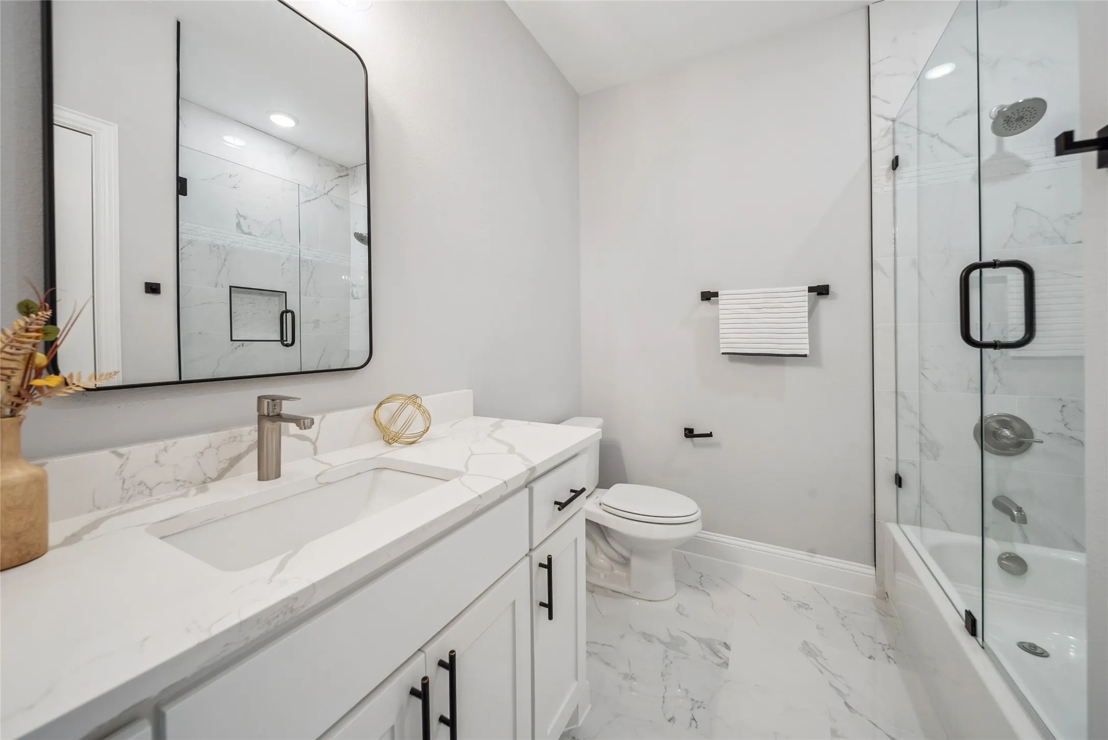 Modern bathroom featuring a white vanity with integrated sink, quartz countertop, and brushed nickel faucet