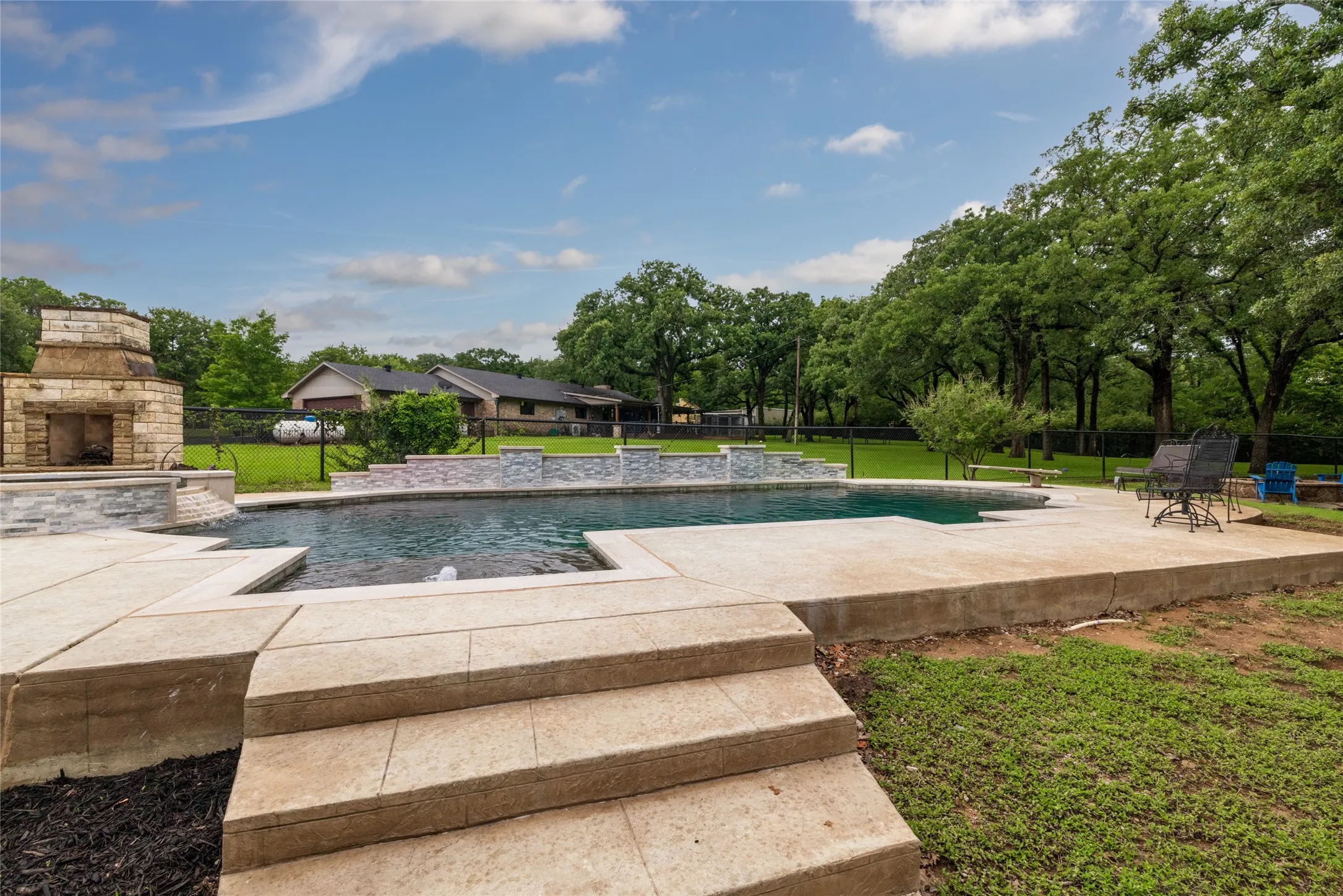 Custom outdoor pool with integrated spa and water features