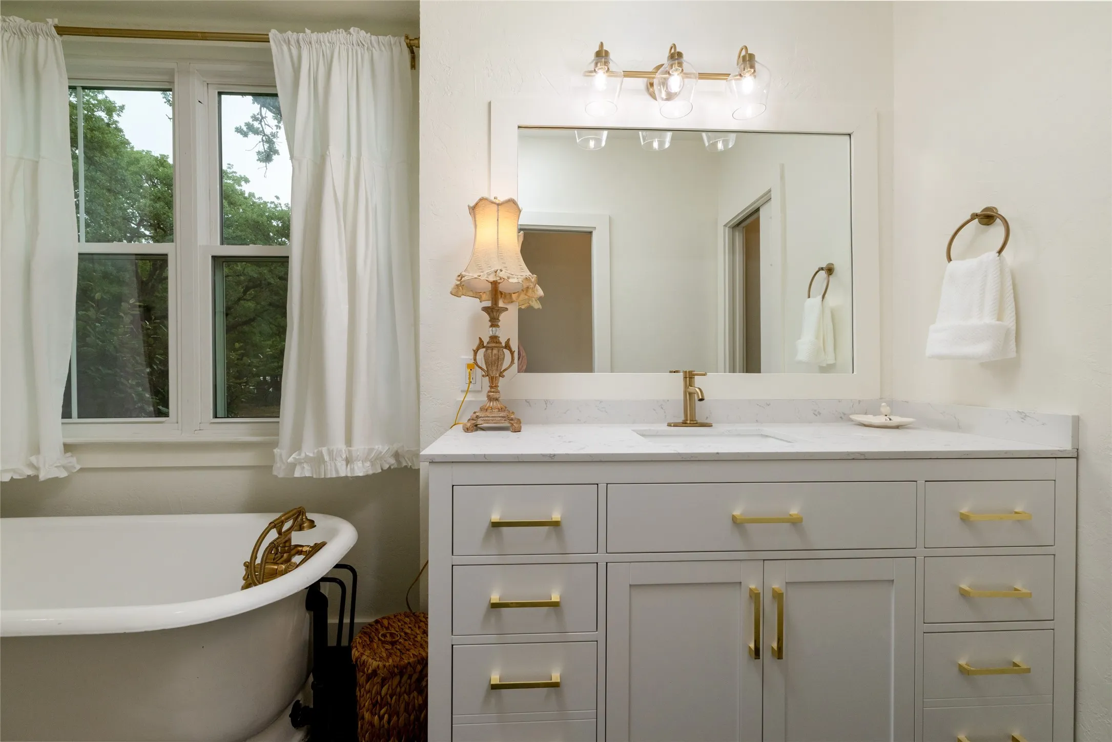 White clawfoot tub with brass fixtures