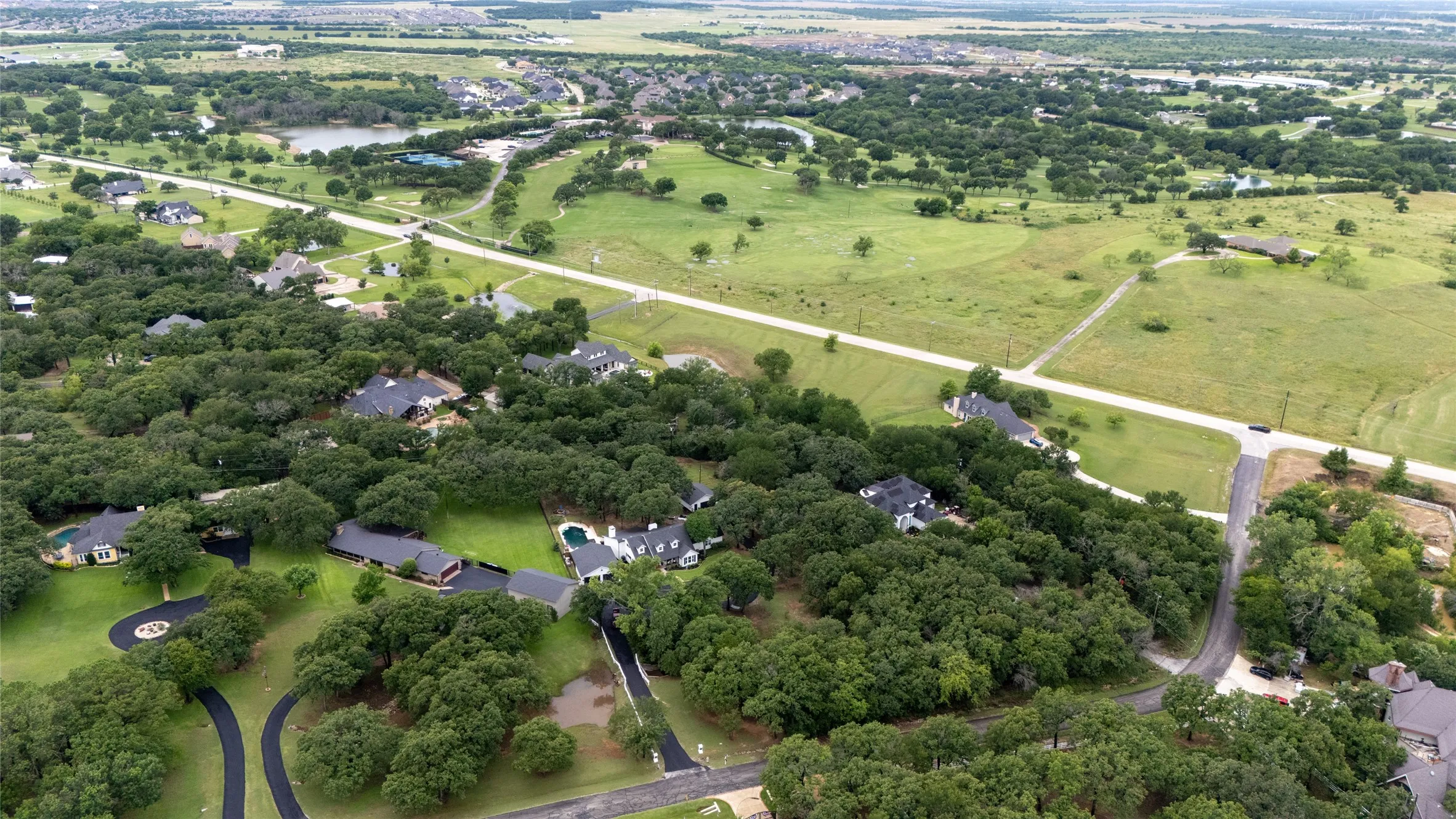 Aerial perspective showcasing a residential area with extensive tree coverage