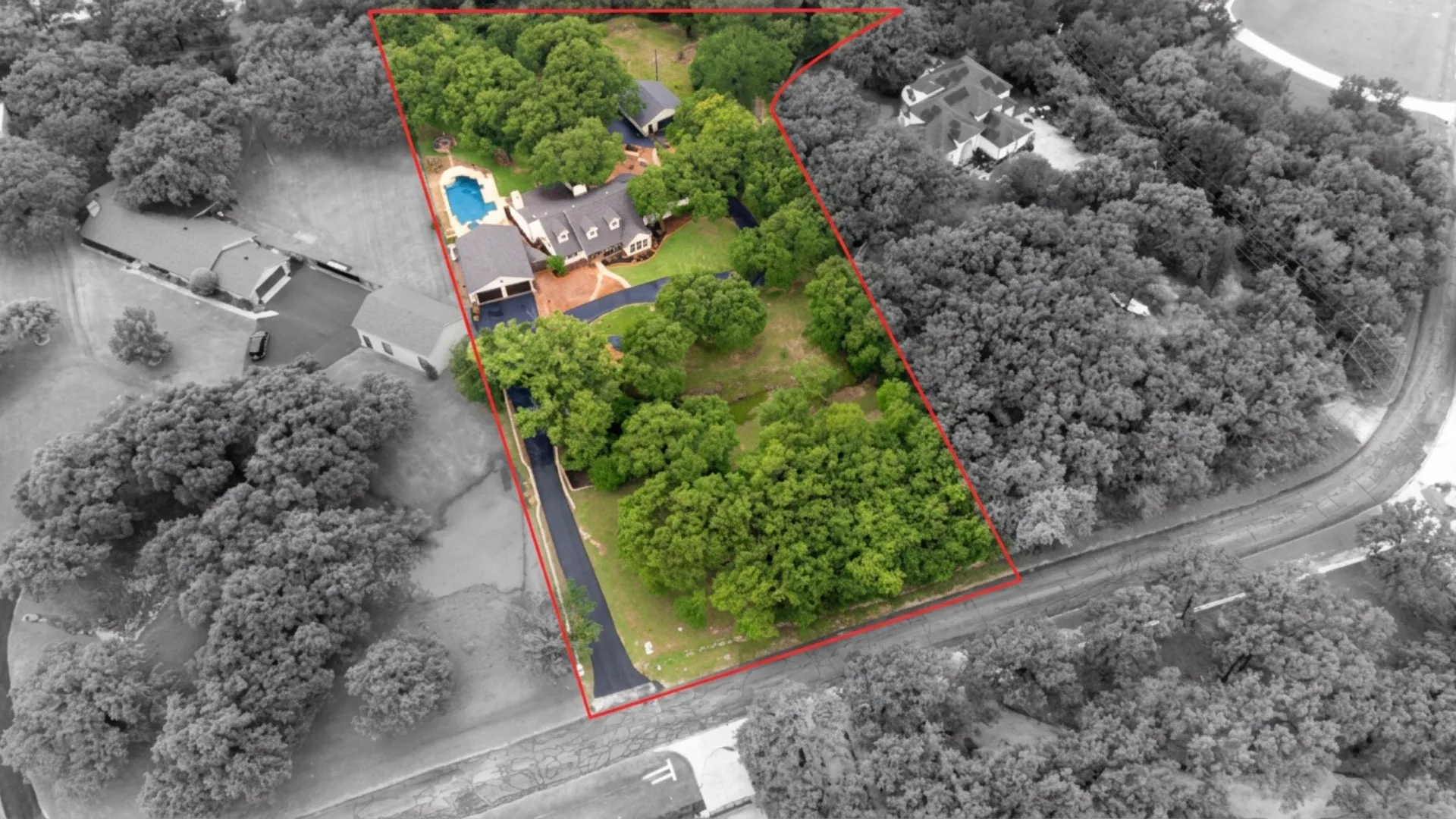 Aerial perspective showcasing a sprawling property with extensive tree coverage and a private swimming pool