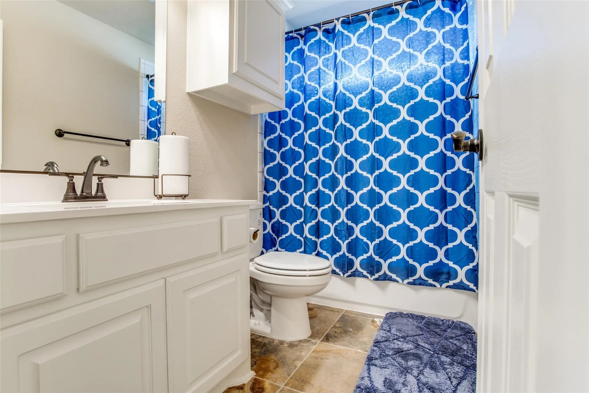 Bathroom featuring a white vanity with panel cabinetry and a white countertop