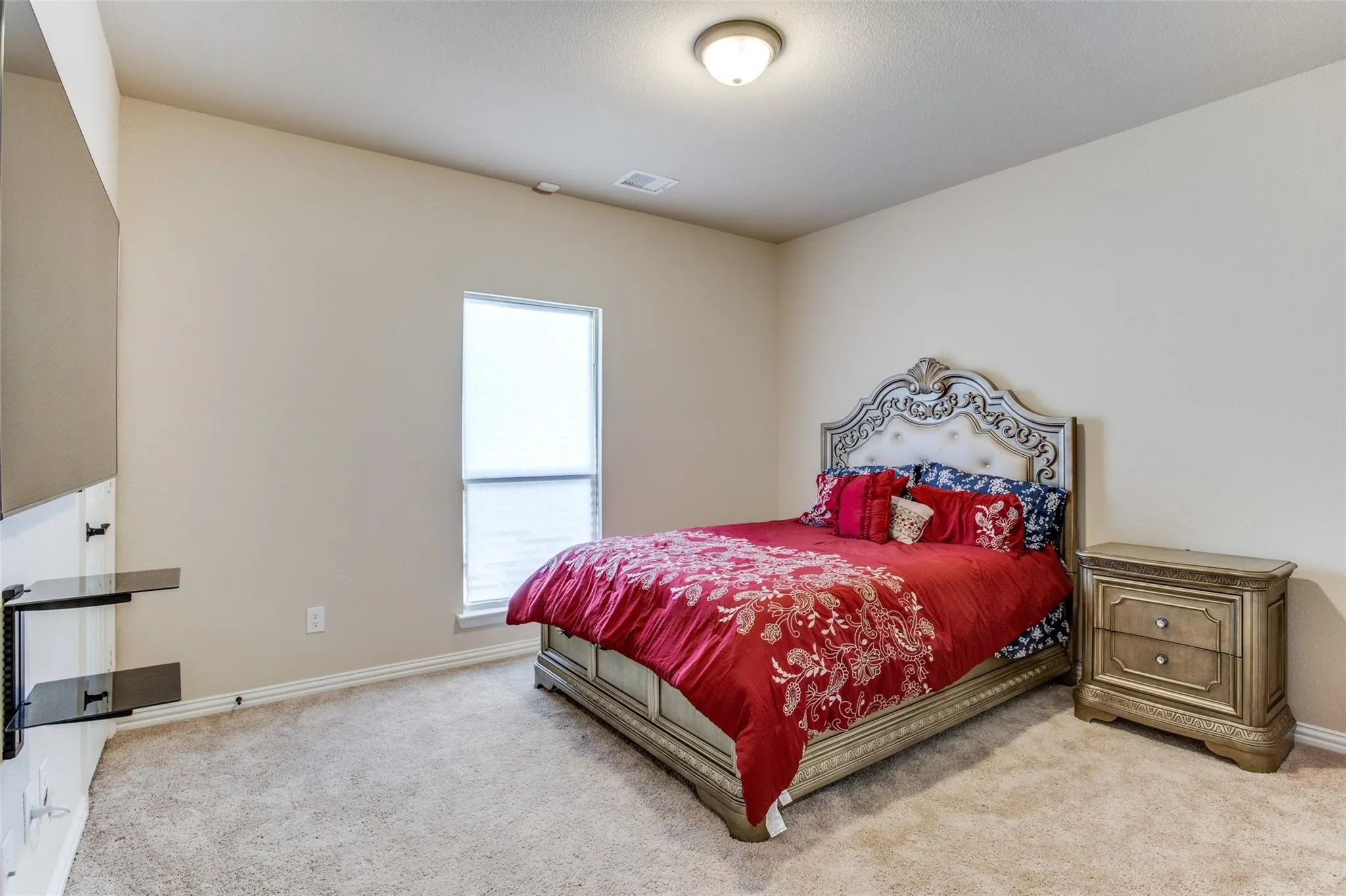Carpeted room featuring a single window with blinds, a ceiling-mounted light fixture, and neutral-toned walls