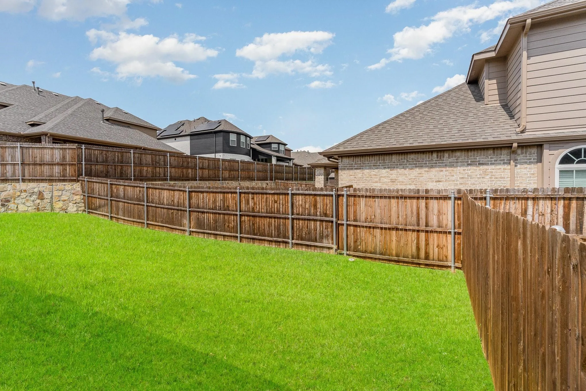 Expansive green lawn with wood privacy fencing