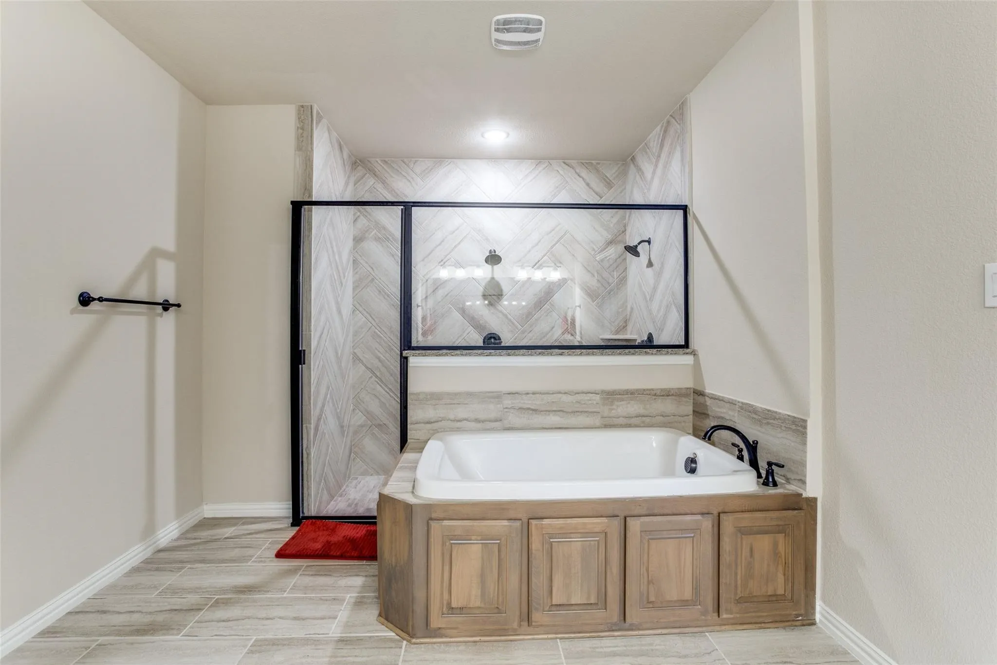 Walk-in shower with clear glass enclosure and tile surround