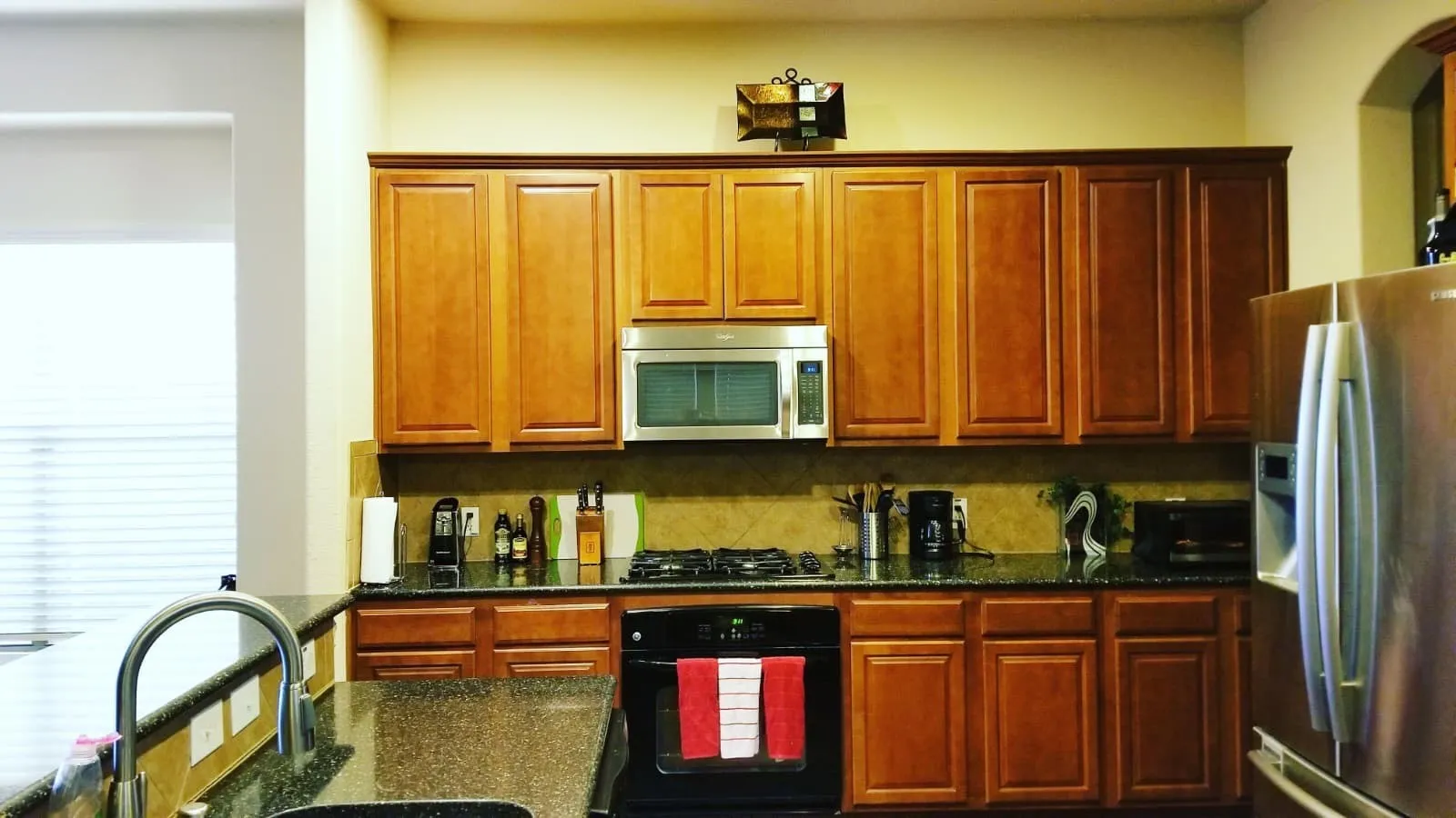 Kitchen with abundant wood cabinetry, dark countertops, and stainless steel appliances