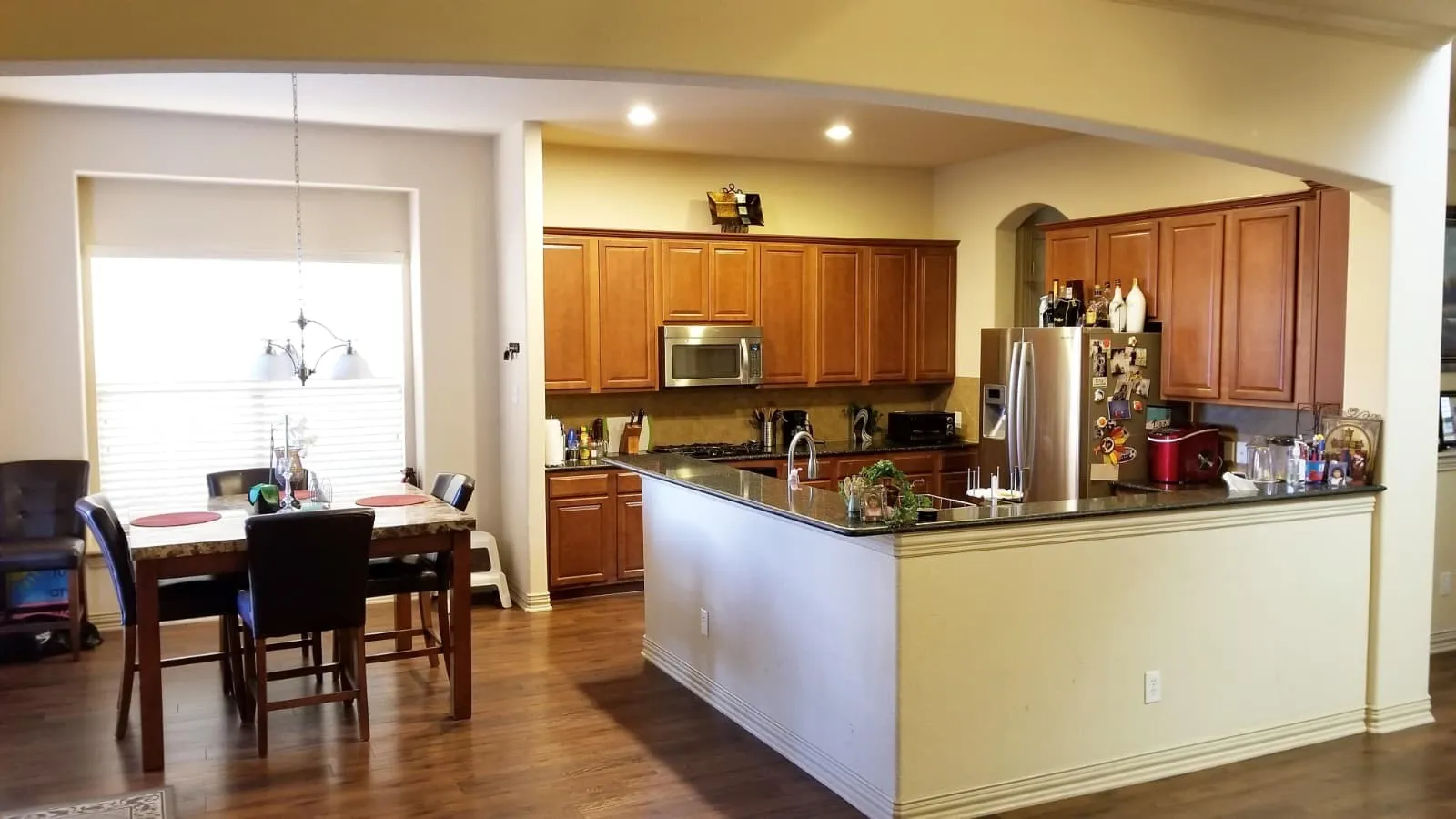 Open-concept kitchen and dining area featuring wood-finish flooring