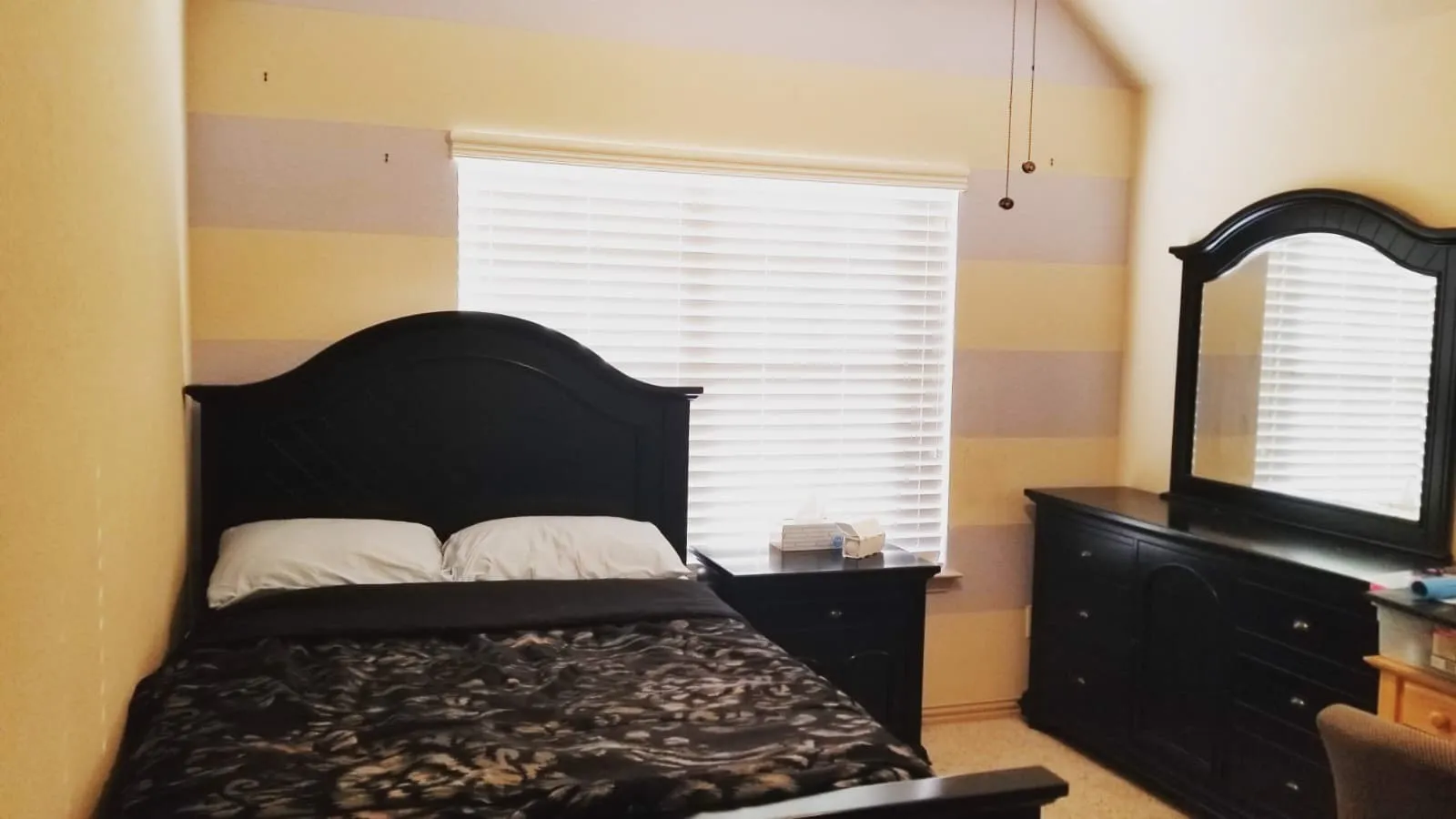 Carpeted bedroom with a window featuring horizontal blinds