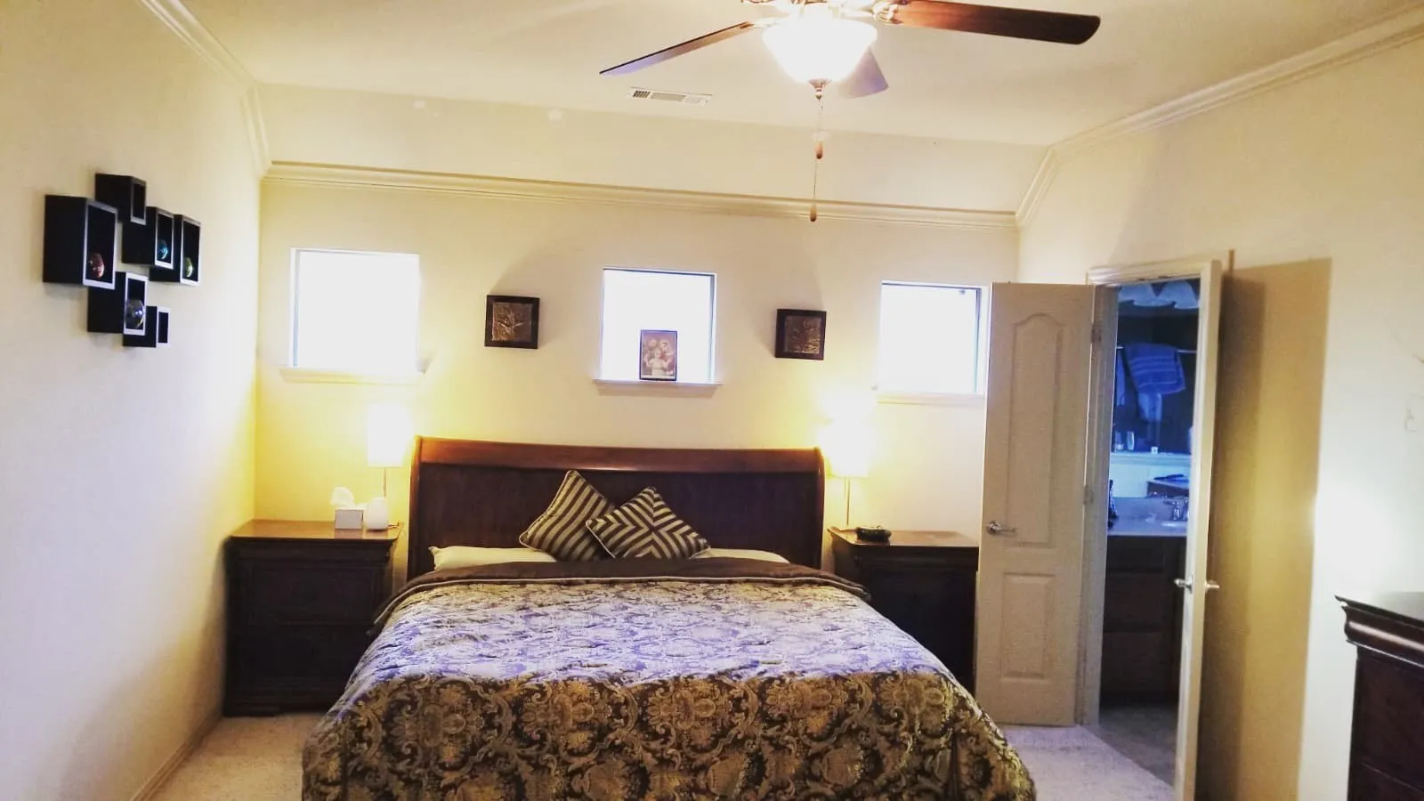 Spacious room featuring a ceiling fan with integrated lighting, crown molding, light-colored walls, and carpeting