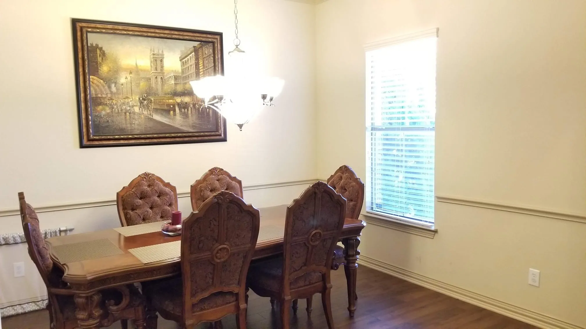 Wood-finish flooring accentuates this room featuring neutral wall tones and decorative chair rail molding