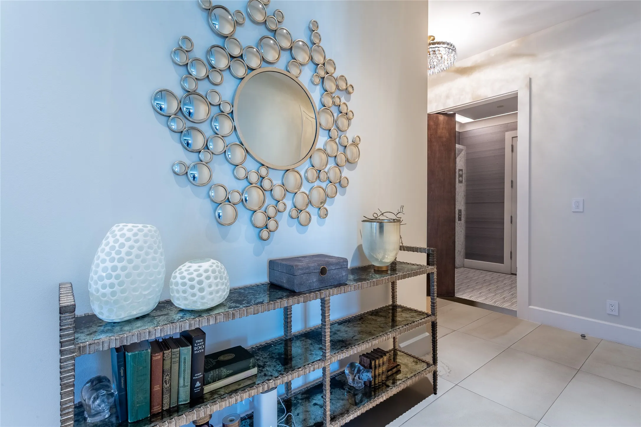 Foyer has Italian Avorio limestone floors & crystal chandelier.