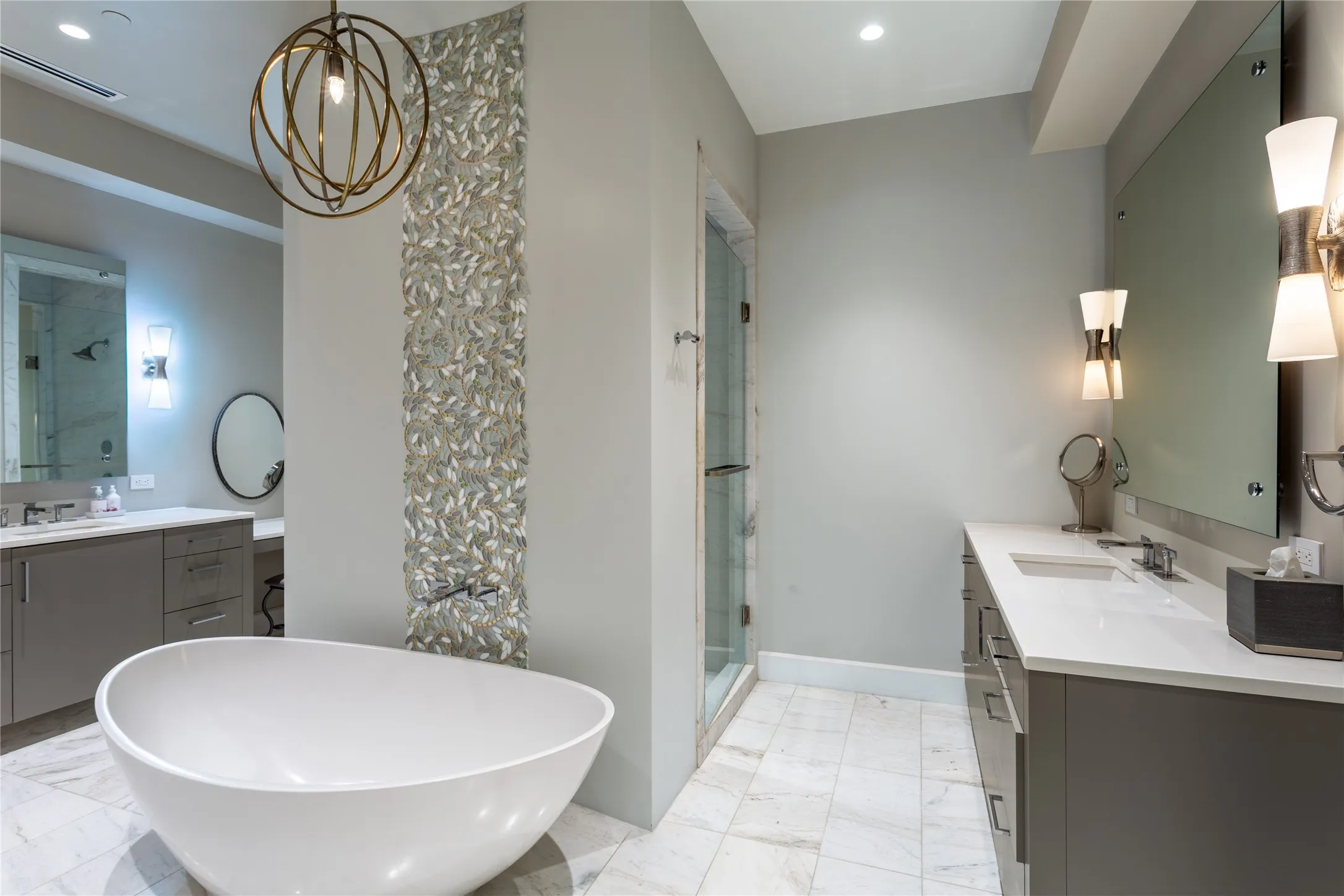 Free-standing soaking tub accented by "City Lights Indirama Barcelona" glass mosaic.