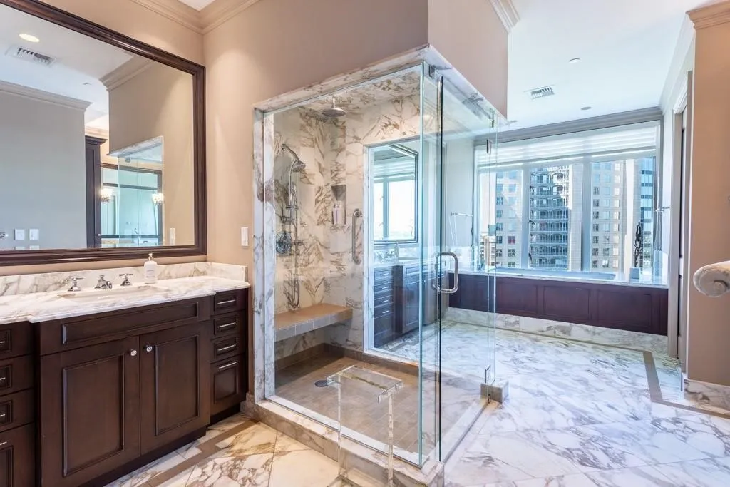 Oversized no-curb shower with dual heads separates the vanities.