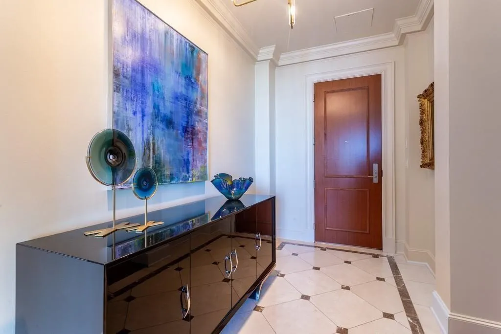 Crema Marfil marble entry inlaid with Light Emperador marble.