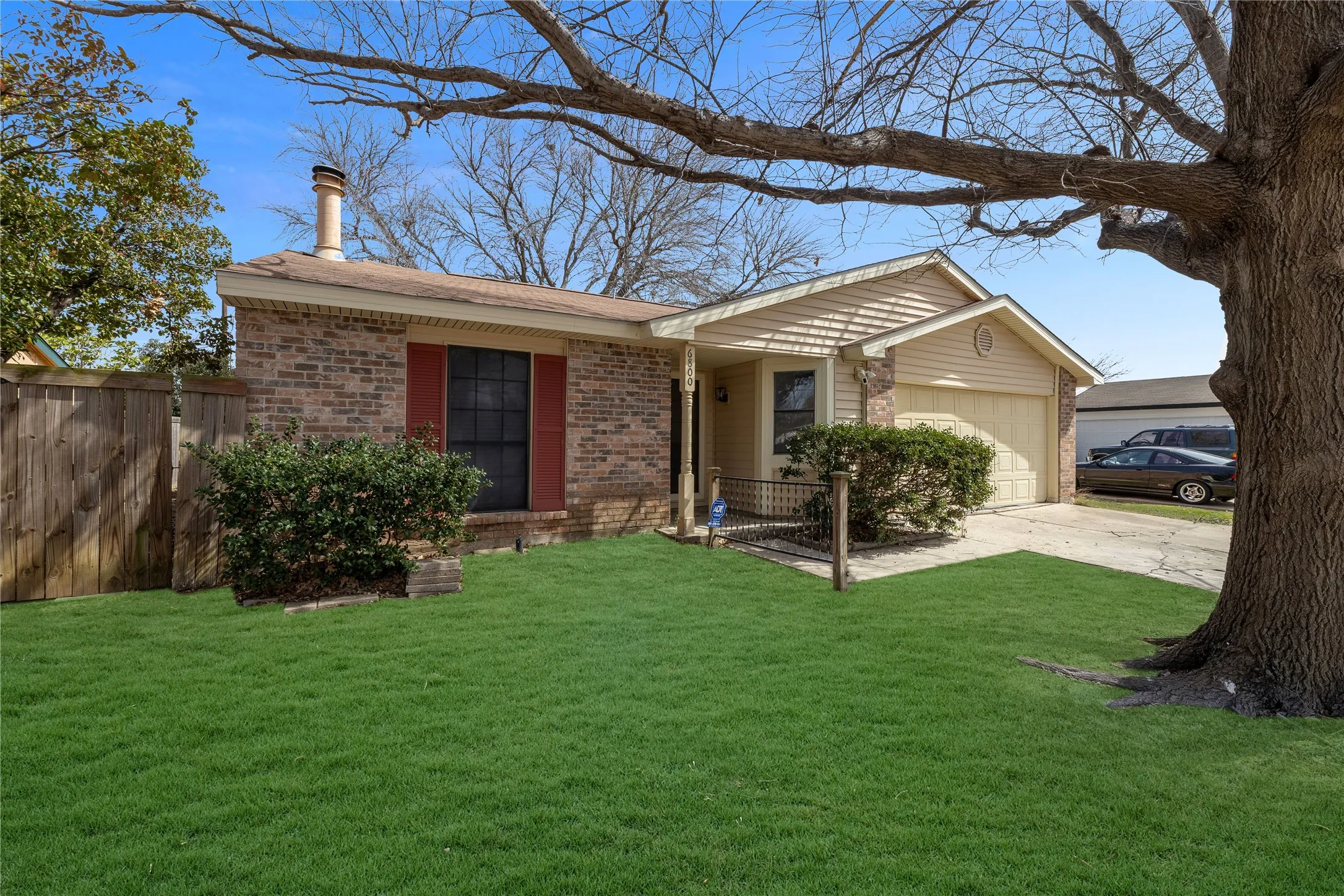 Brick and siding exterior featuring a single-car garage and a paved driveway