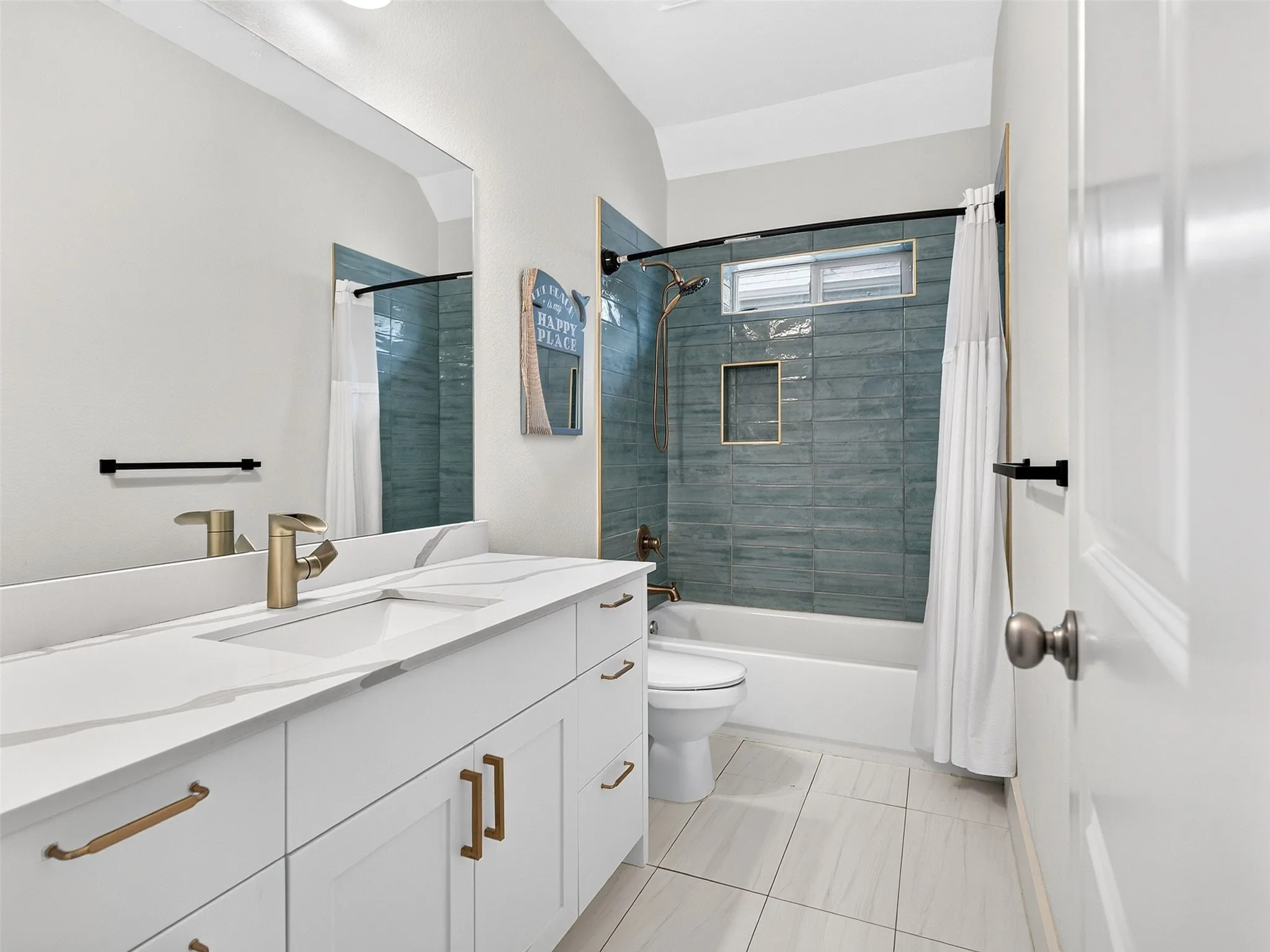 Contemporary bathroom featuring a spacious vanity with a white countertop and gold-toned hardware, a white undermount sink, and a gold-toned faucet