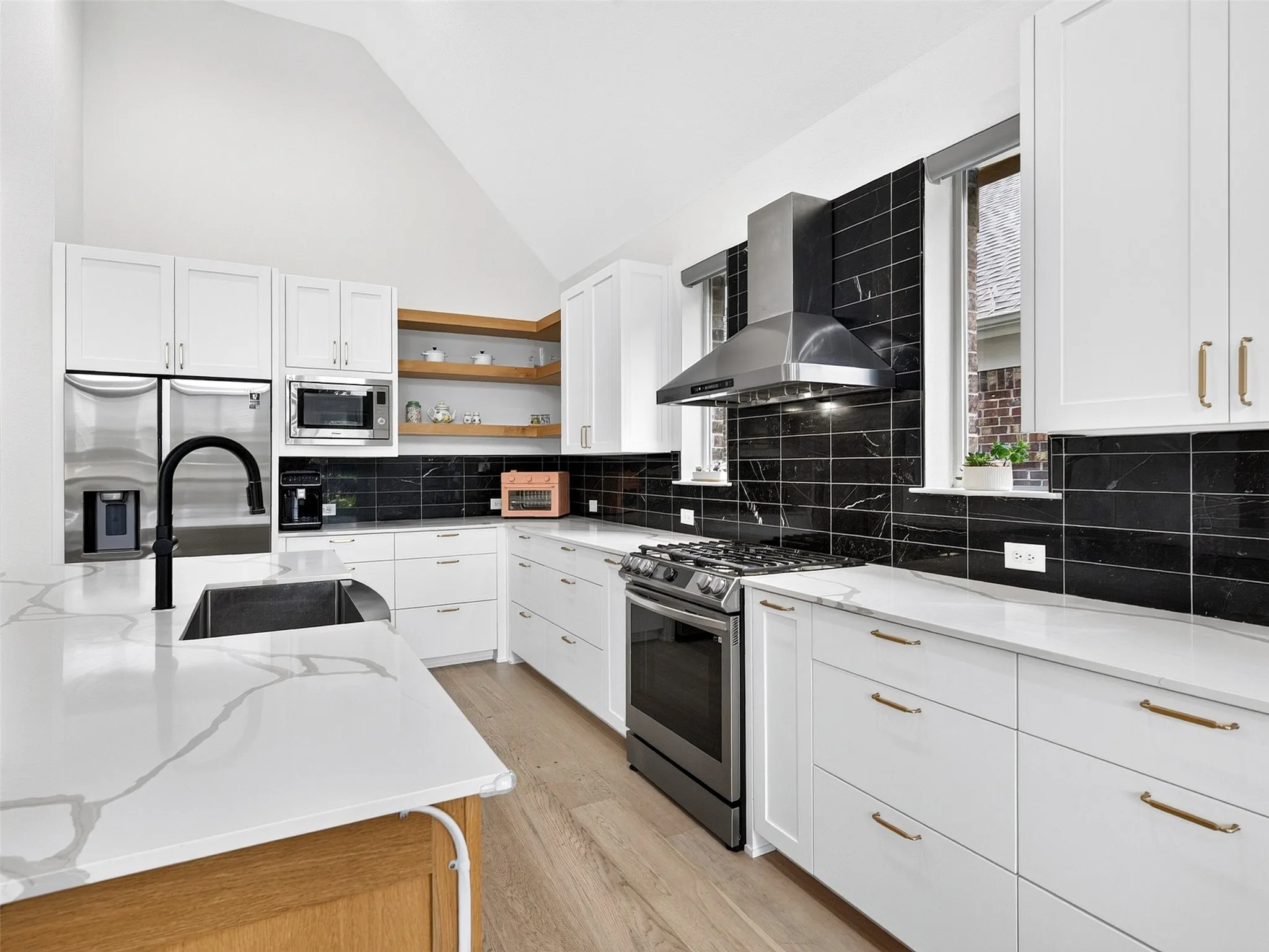 Kitchen featuring a vaulted ceiling and light wood-finish flooring
