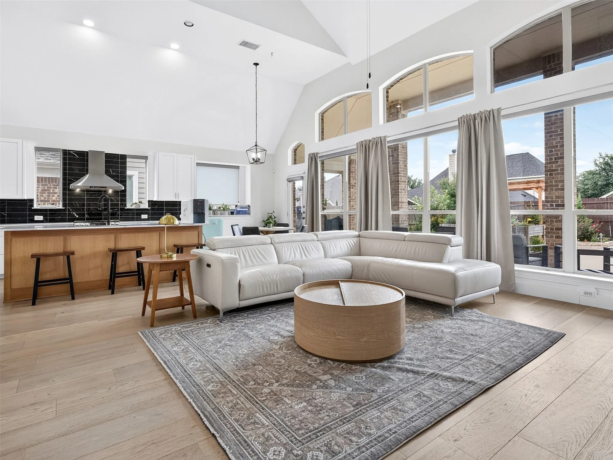 Expansive open-concept living space featuring vaulted ceilings and light wood-finish flooring