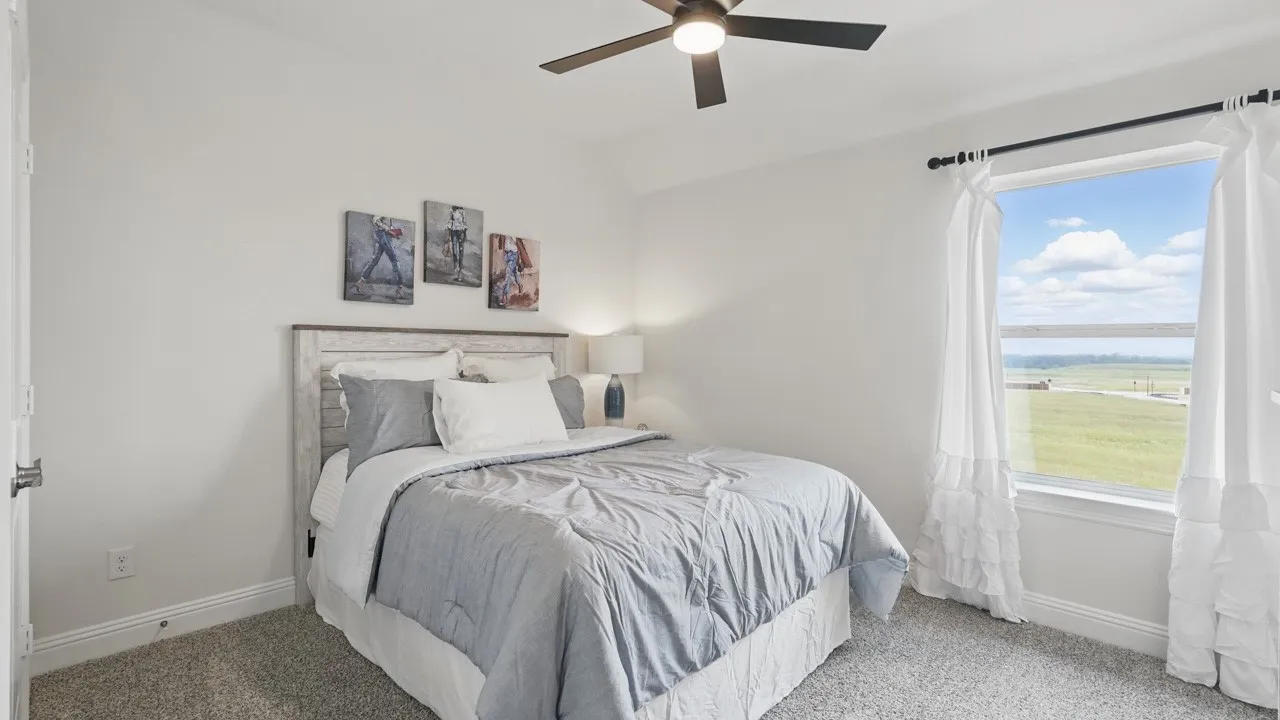 Bedroom featuring a large window, neutral wall paint, and plush carpet flooring