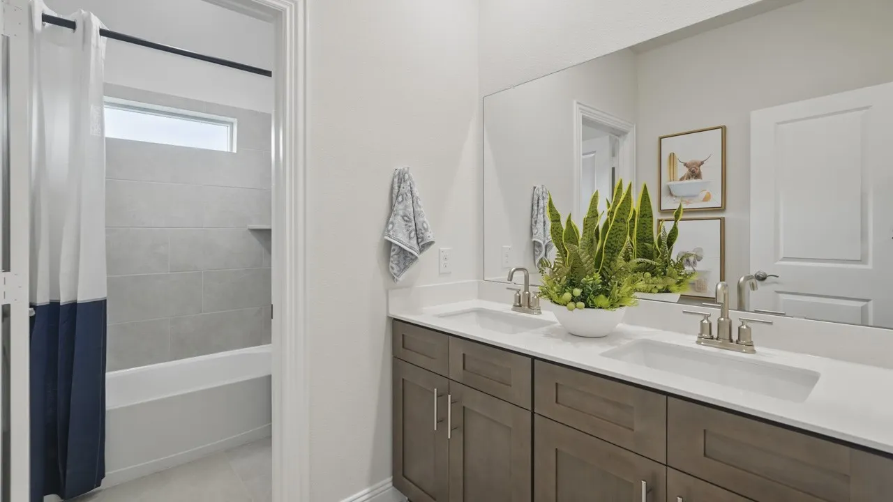 Double vanity with dual undermount sinks, white countertops, and wood-finish cabinetry