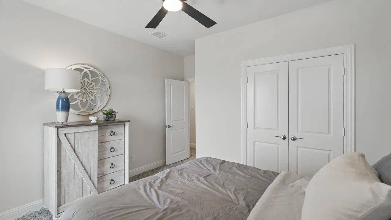 Neutral-toned room featuring a ceiling fan, light gray walls, and white trim