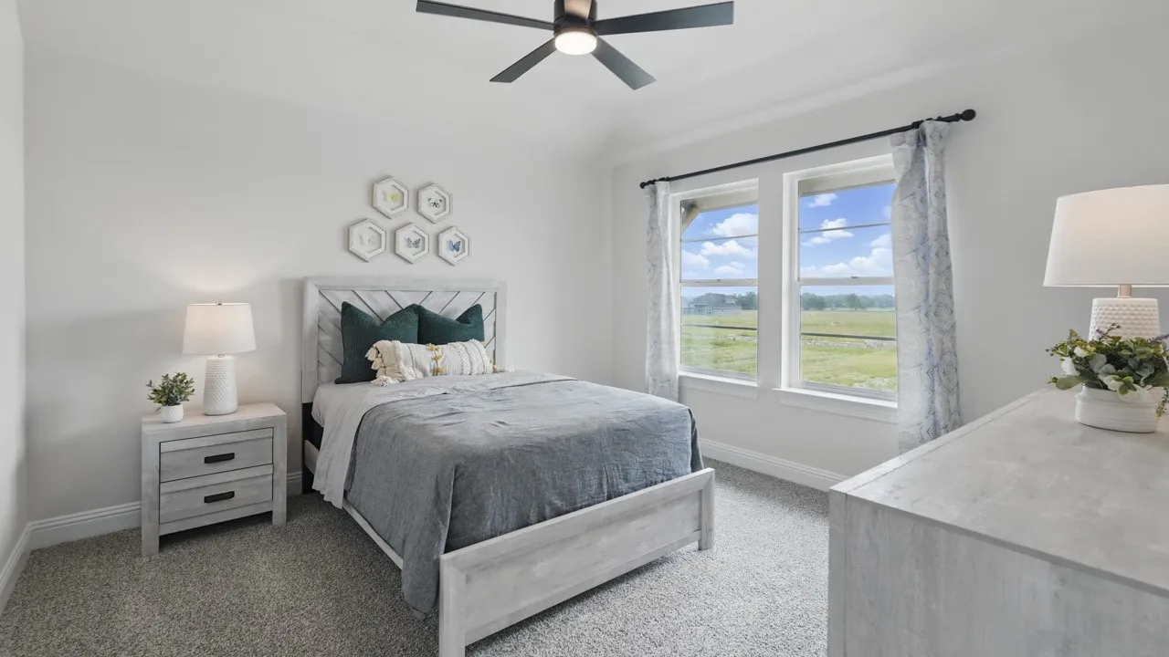 Carpeted bedroom featuring a vaulted ceiling with a ceiling fan, two windows with white trim, and a horizontal wood-slat headboard