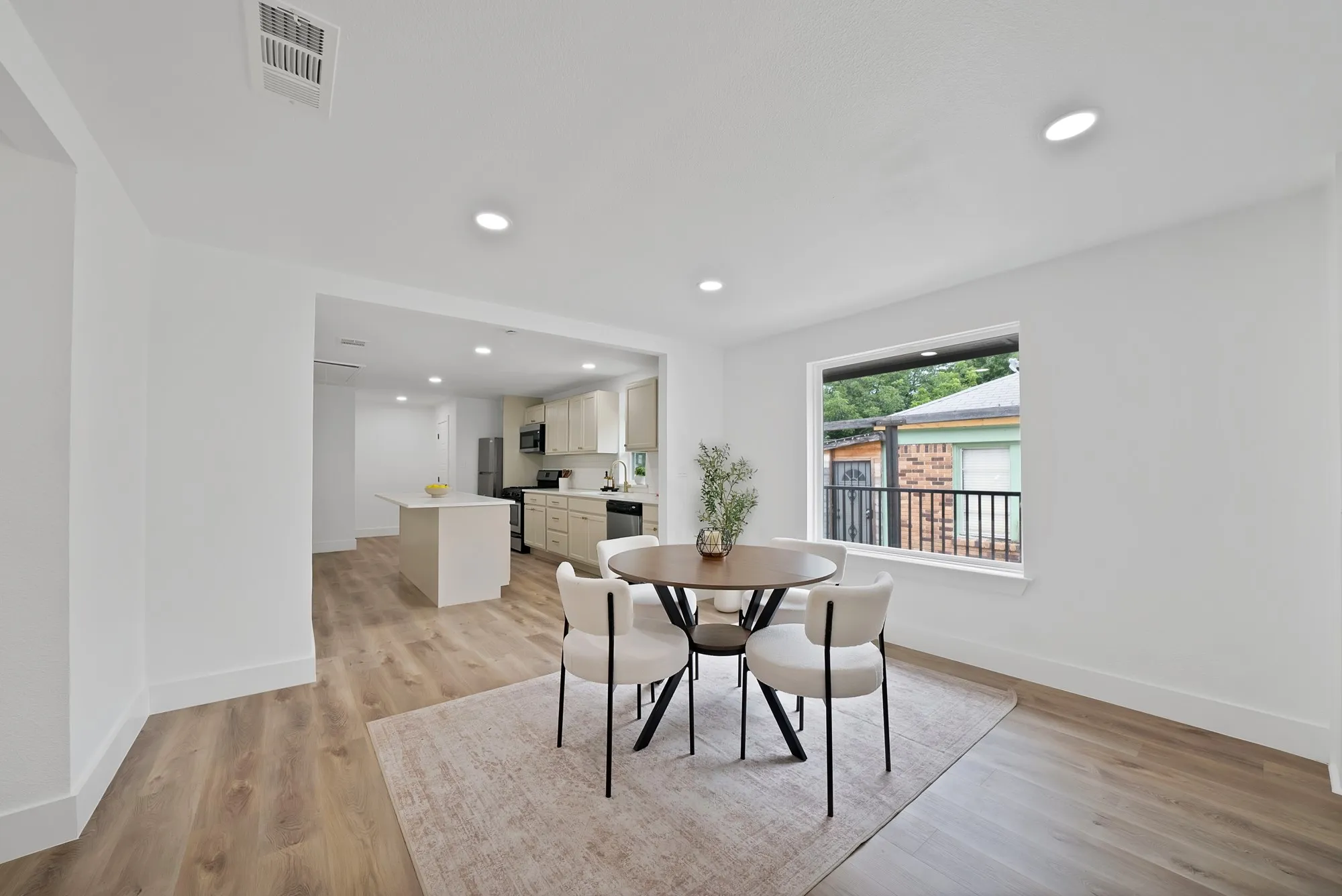 Open concept living space featuring wood-finish flooring, recessed lighting, and a white trim window